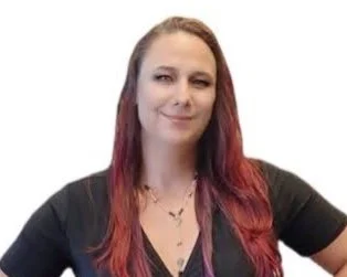A woman with long red hair smiling, wearing a black shirt and a necklace, against a white background.
