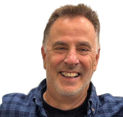 A smiling man with short hair and a beard, wearing a blue checkered shirt.
