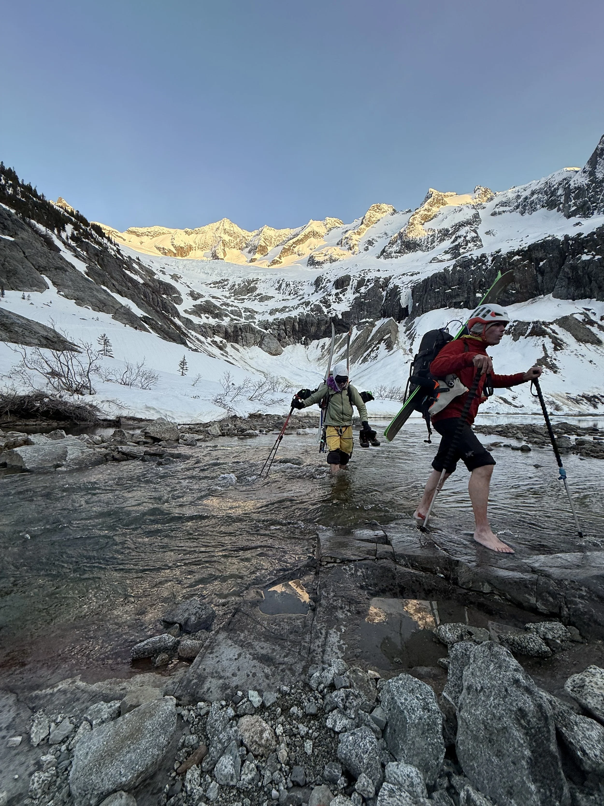 Crossing the stream outlet getting into camp next to Moraine Lake on the Forbidden Tour. Photo by Ian Nicholson