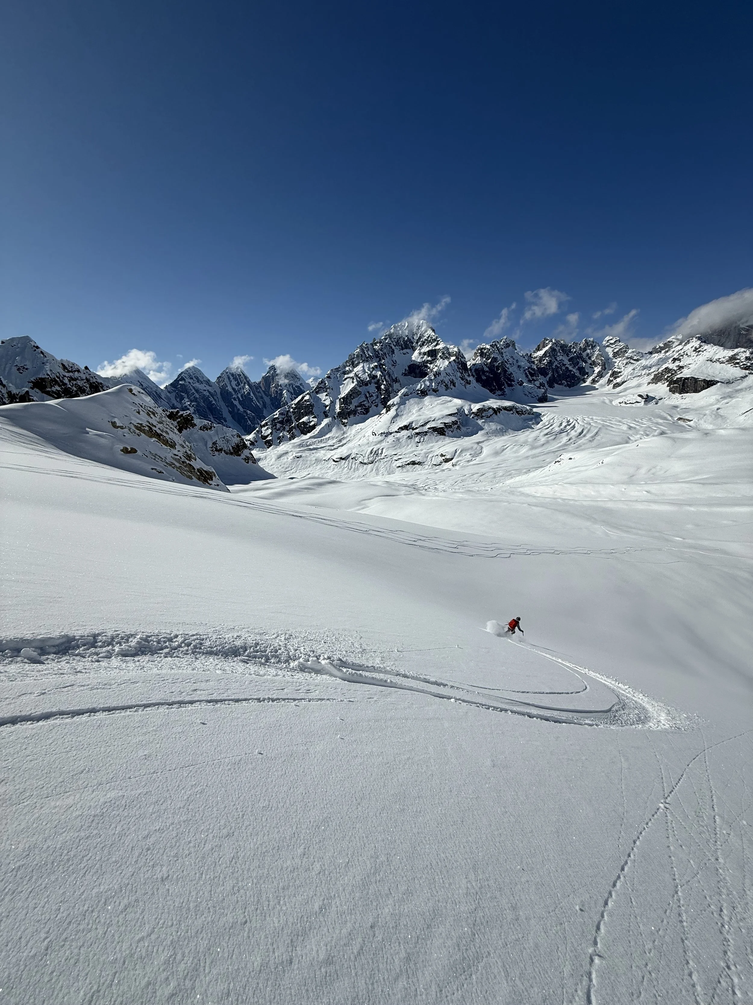 Skiing down with the Great Ruth Gorge in the background while skiing touring in the Alaska Range. Photo by Ian Nicholson
