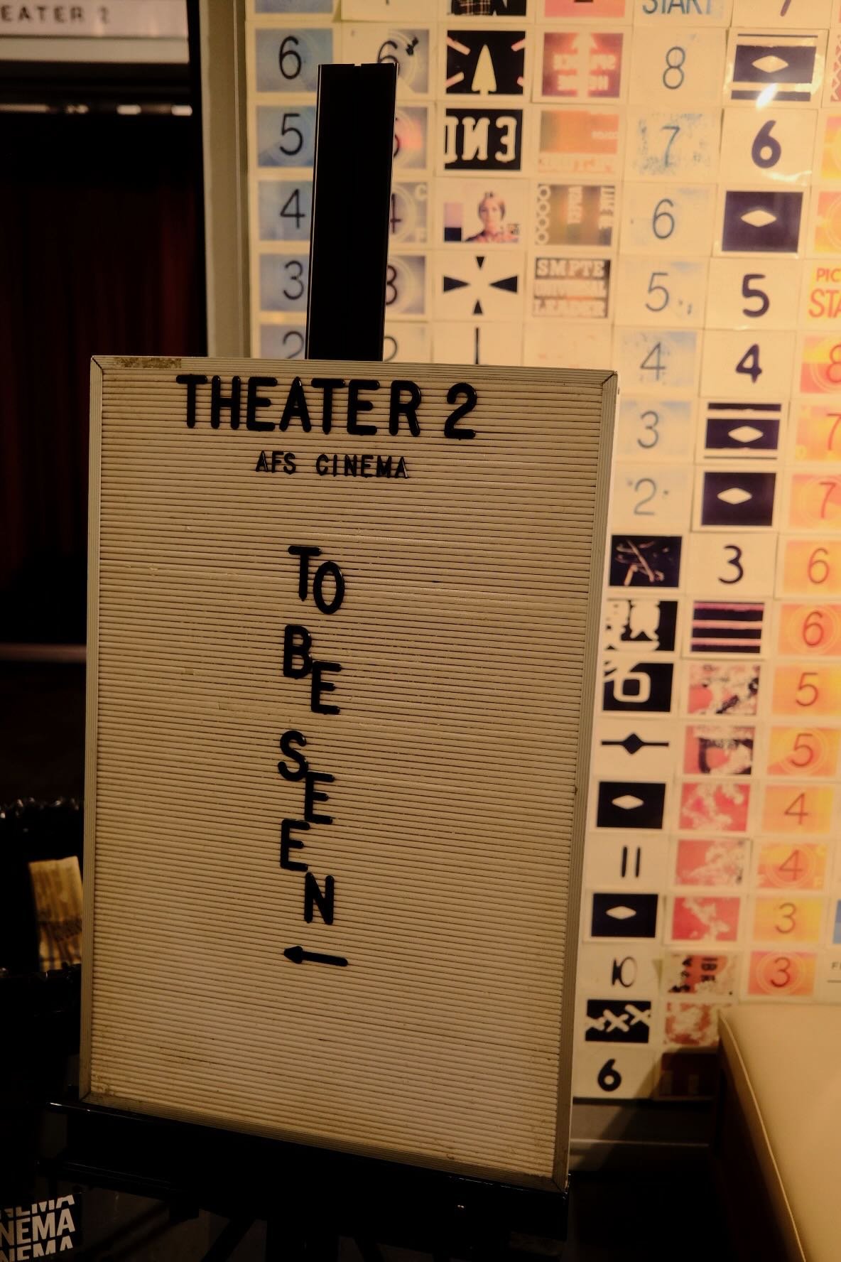 The now playing board with "TO BE SEEN"