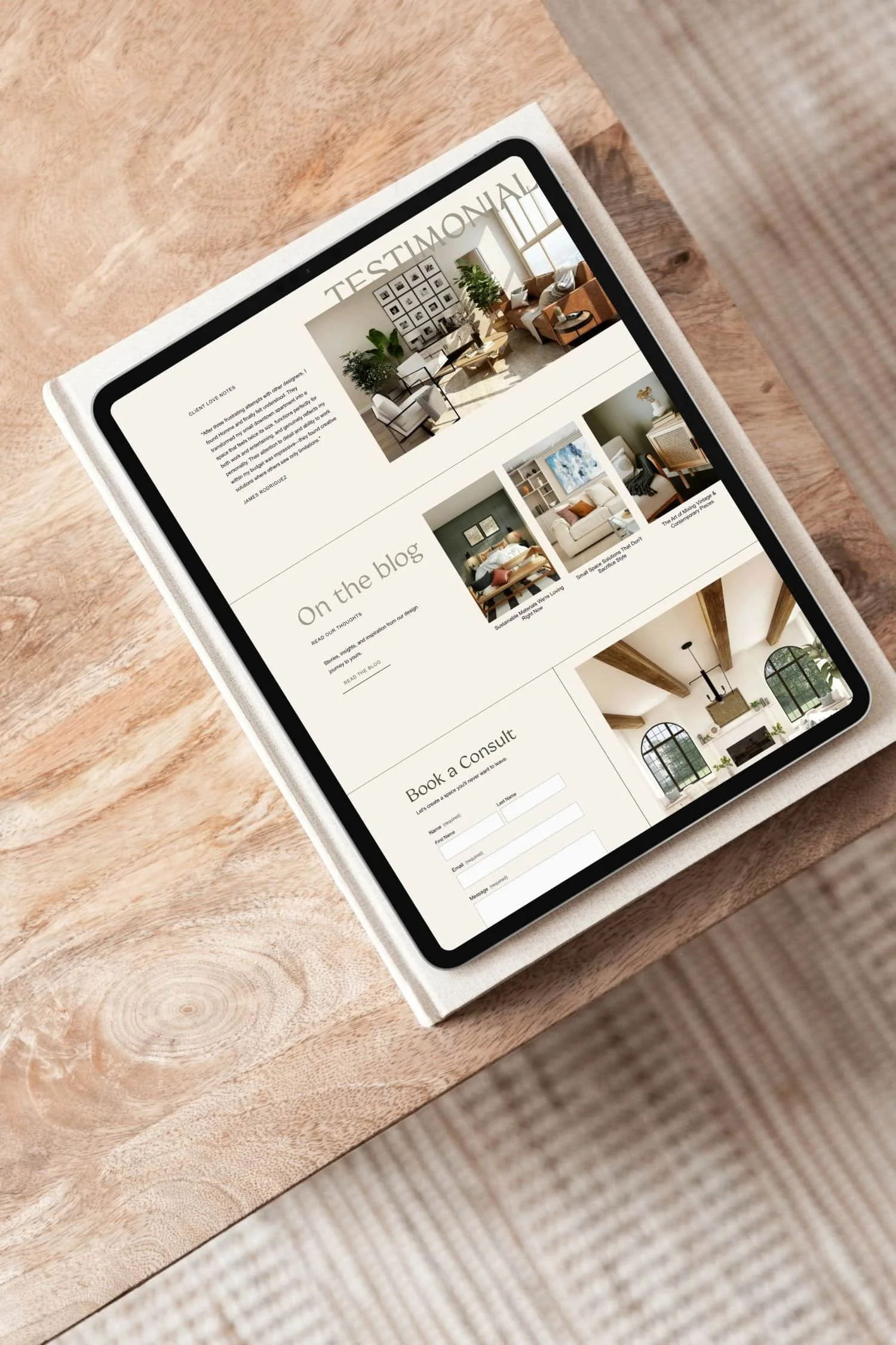 A tablet on a wooden table displaying an interior design blog with images of living rooms and home decor.