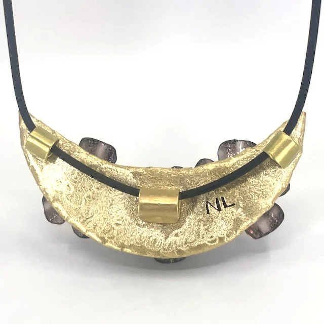 back of crescent pendant with brass setting