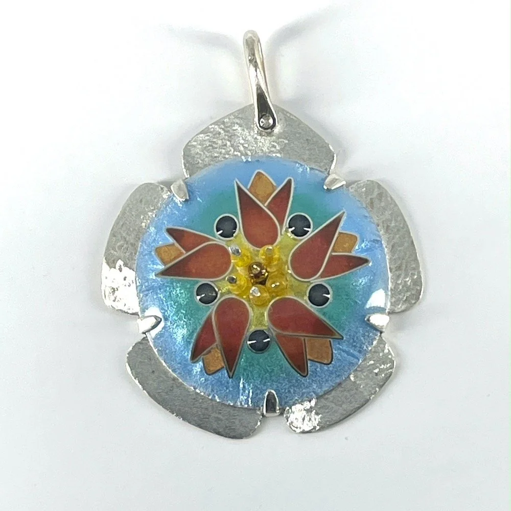 Handmade cloisonné enamel pendant with tulips forming a rose in pink and orange with a yellow center and blue background and silver setting