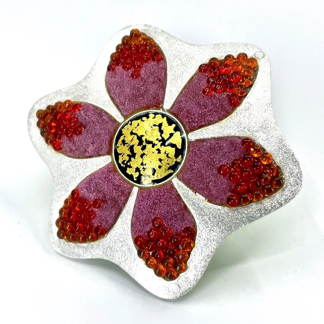 Handmade champlevé silver enamel ring with beads in pink and orange with gold and black center