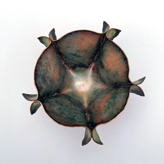 Inside of small cut and shaped copper enamel bowl with fins in green and purple with gold shimmer and beads