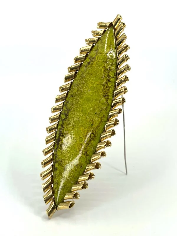Green marquise enamel brooch with curly brass setting