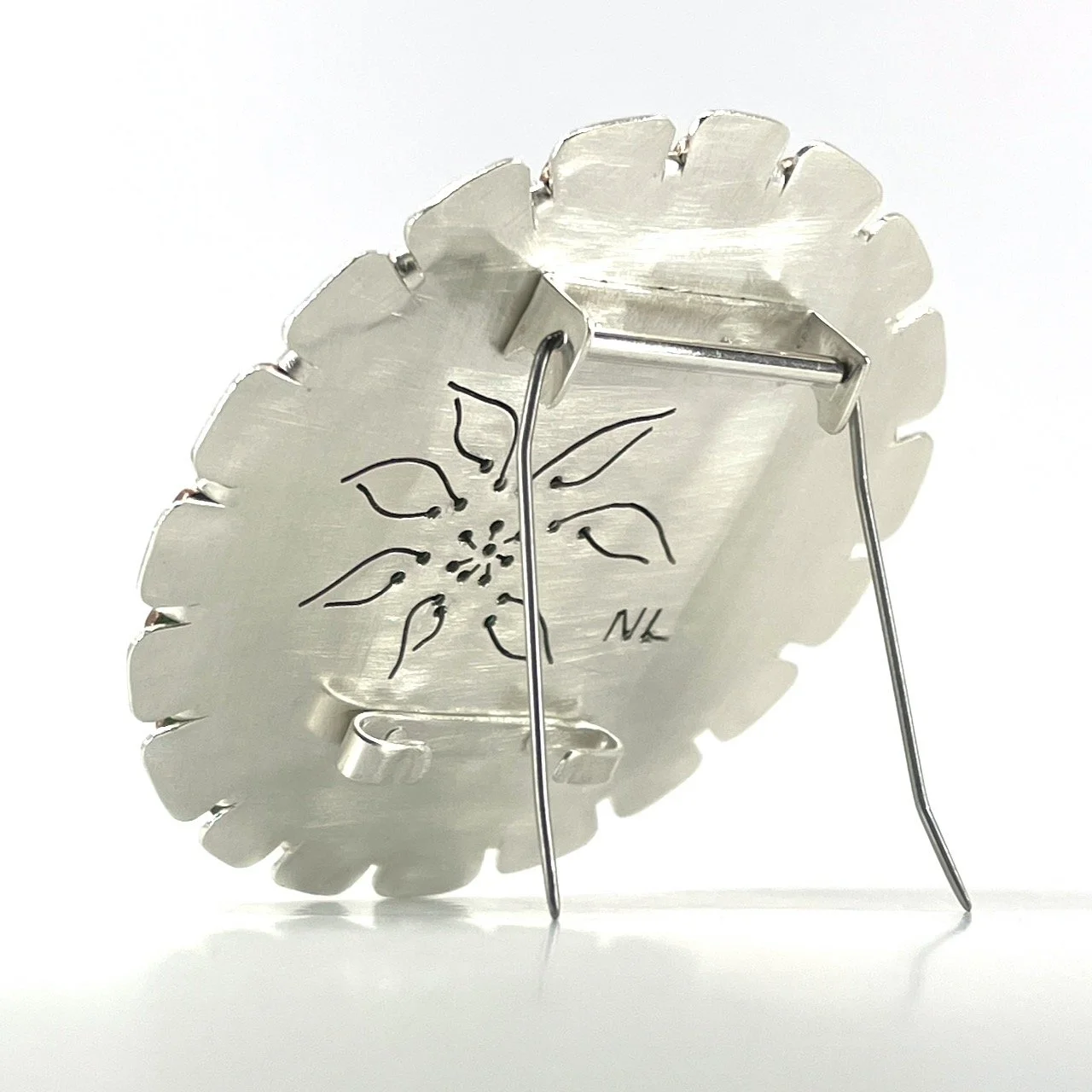 back of round flower shaped silver brooch