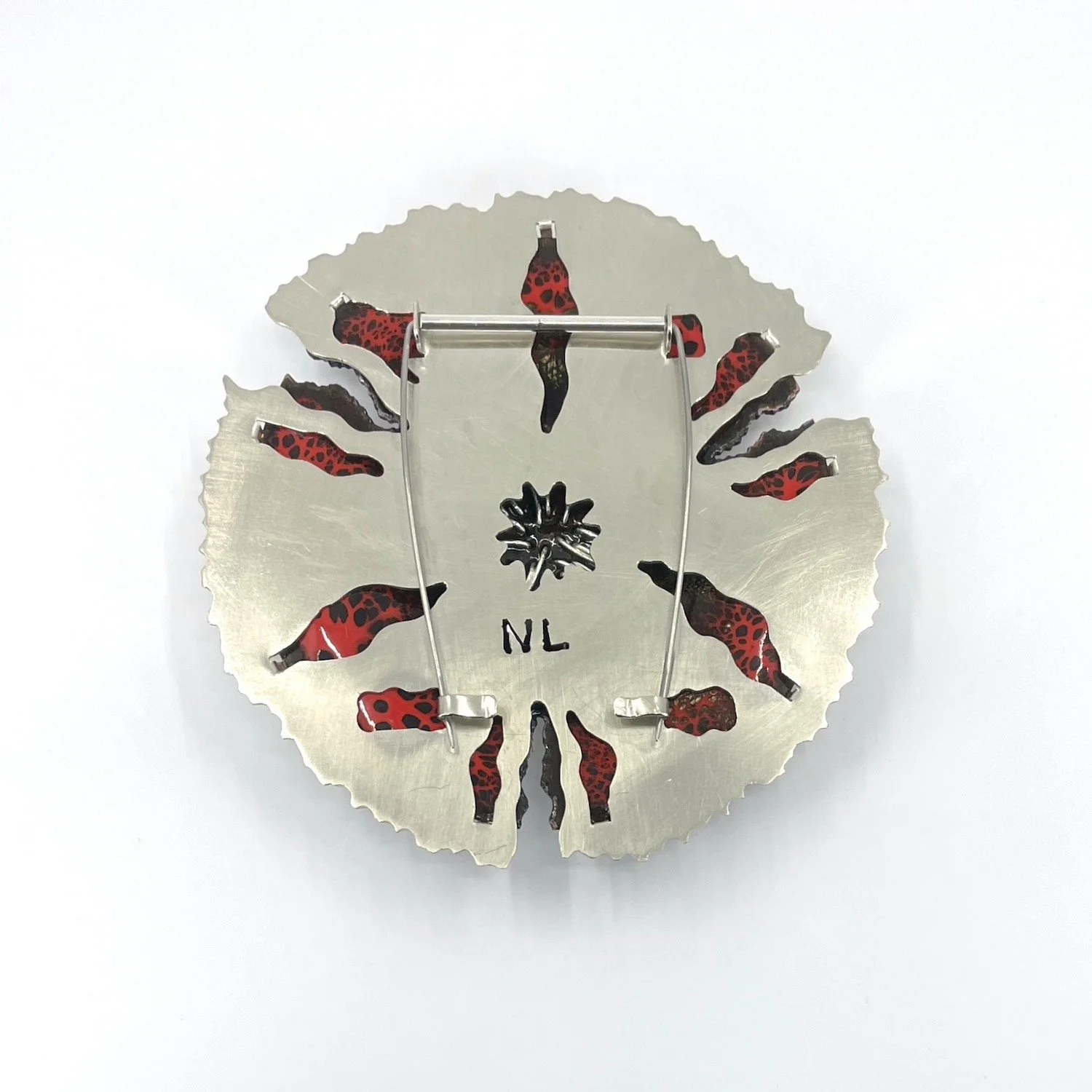 back of round handmade enamel brooch with pierced silver setting