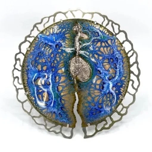 round handmade enamel brooch with blue web and lacy silver setting