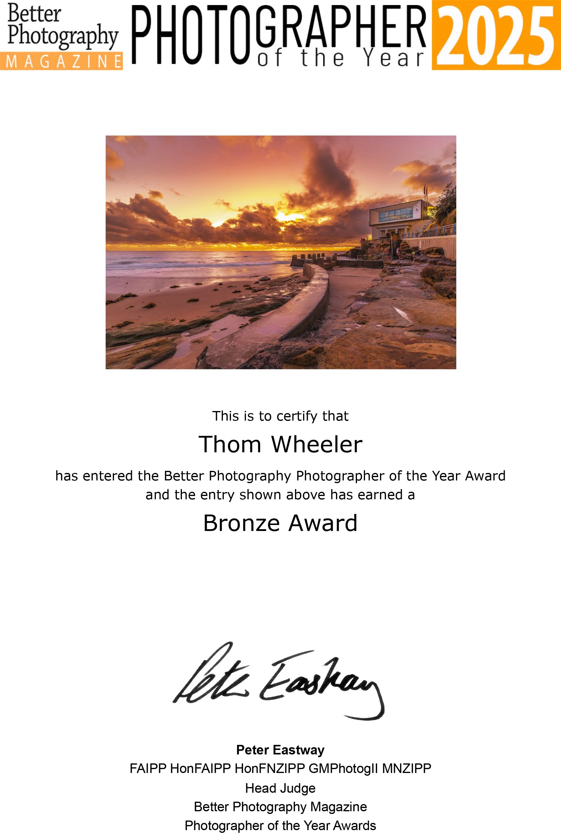 Certificate for Thom Wheeler awarded the Bronze Award in the 2025 Better Photography Magazine Photographer of the Year contest, featuring a sunset over a beach with beachfront building and rocky shoreline.