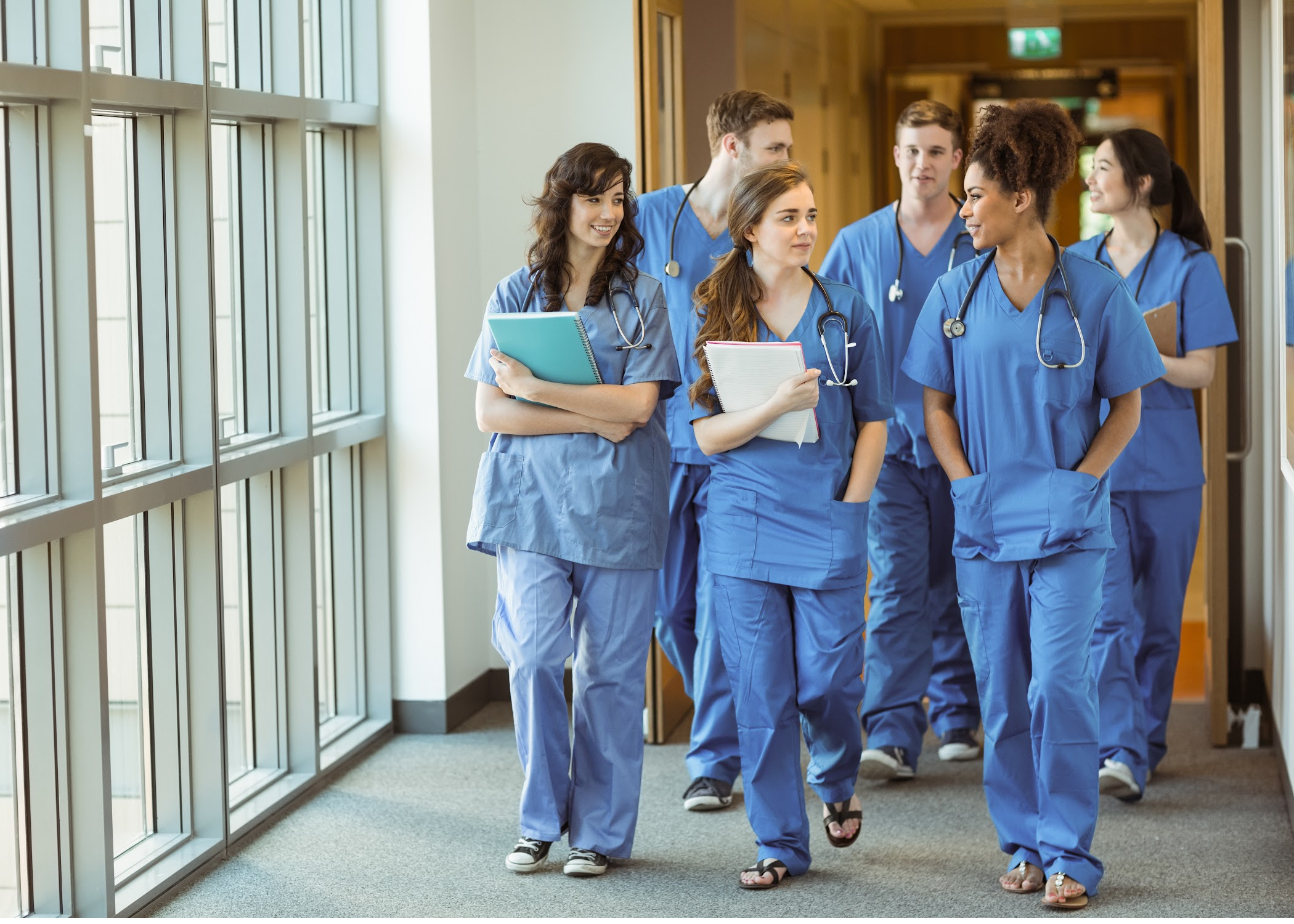 Happy medical students walking down a hallway.
