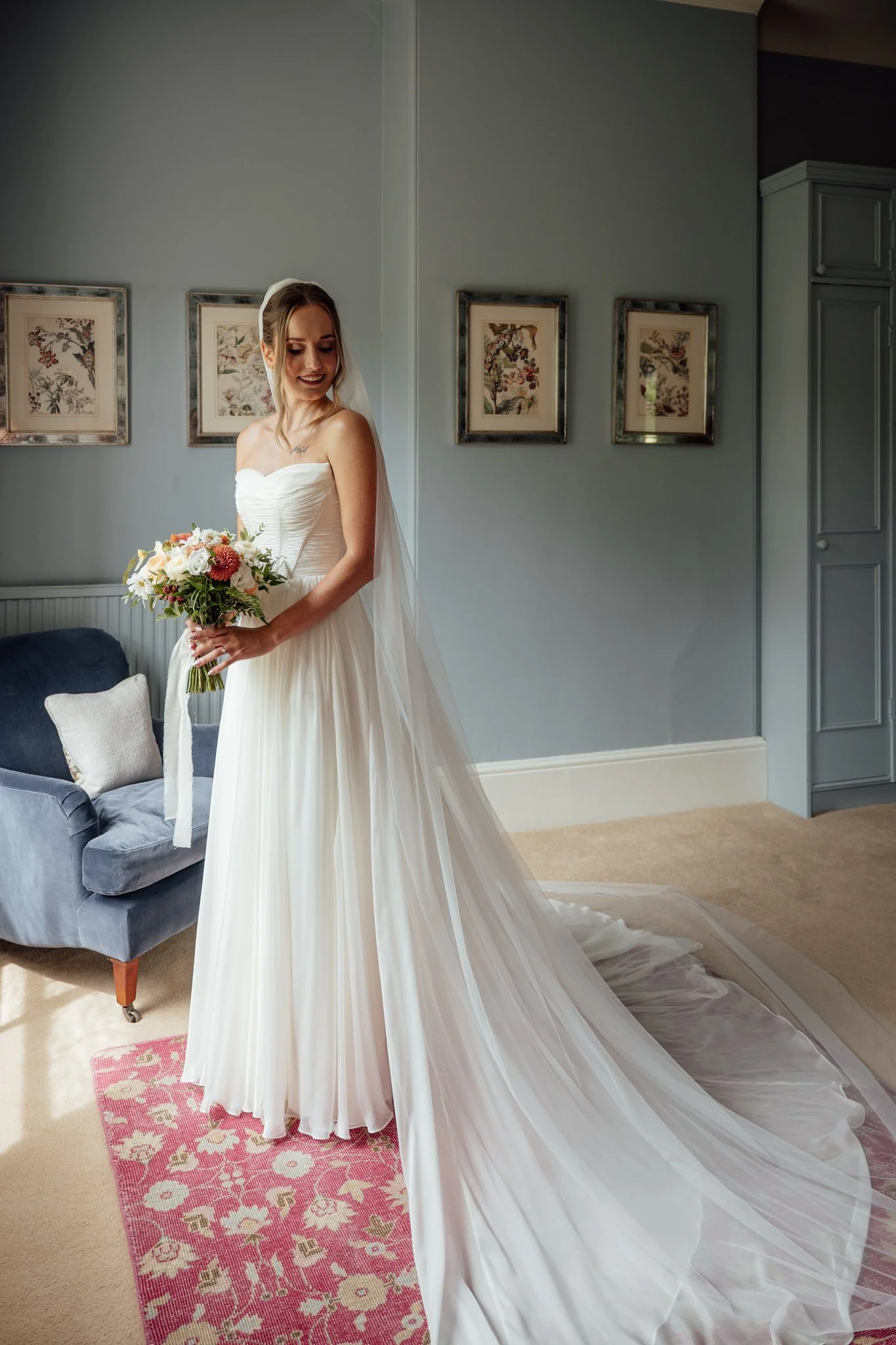 Elegant bridal portrait at Cripps Barn in the Cotswolds, featuring a bride in a strapless tulle gown with a natural bouquet, photographed by Aleksandra Filipek.