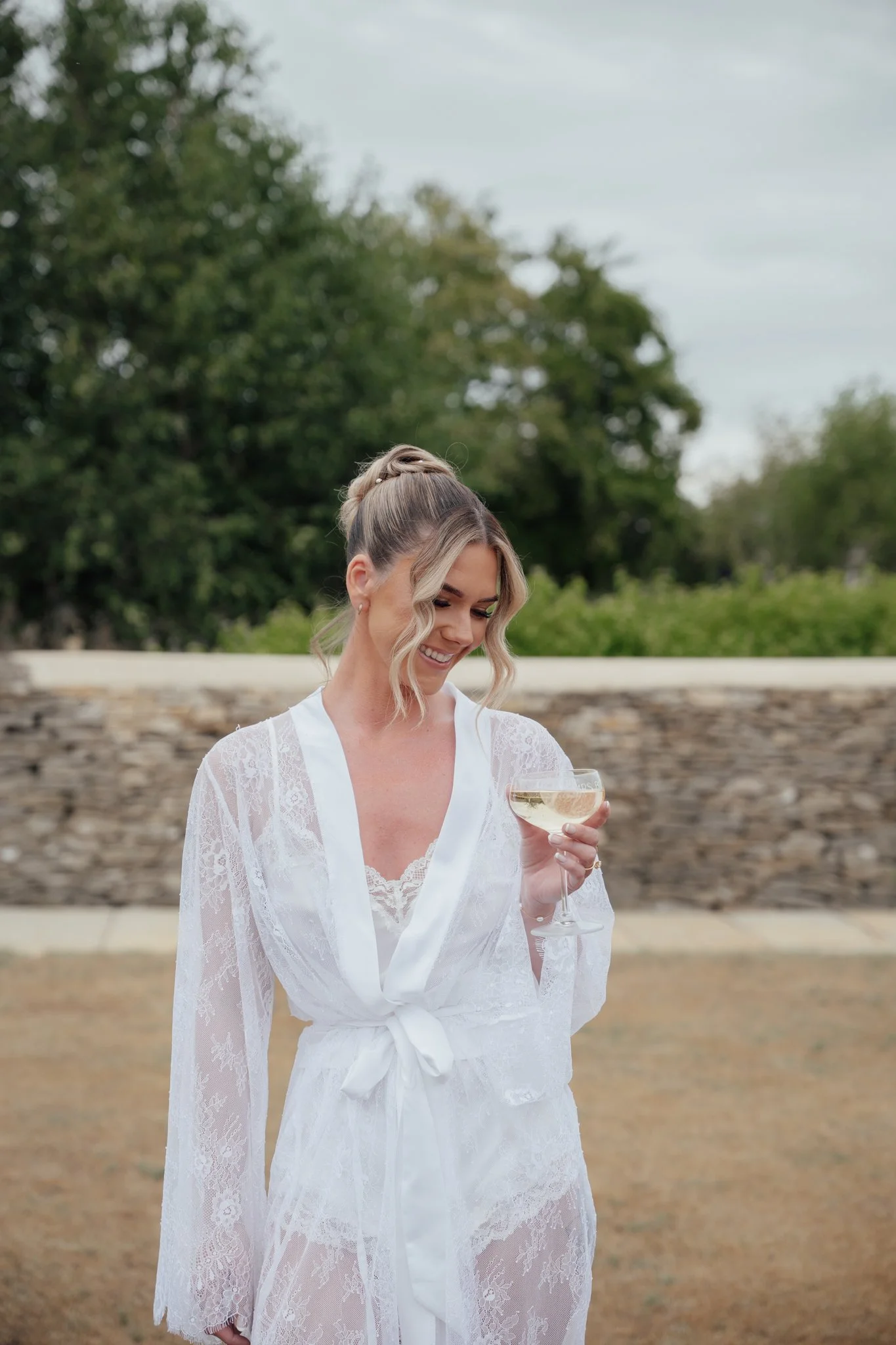 Bride enjoying a quiet moment with a glass of champagne during her getting ready morning at Caswell House.
