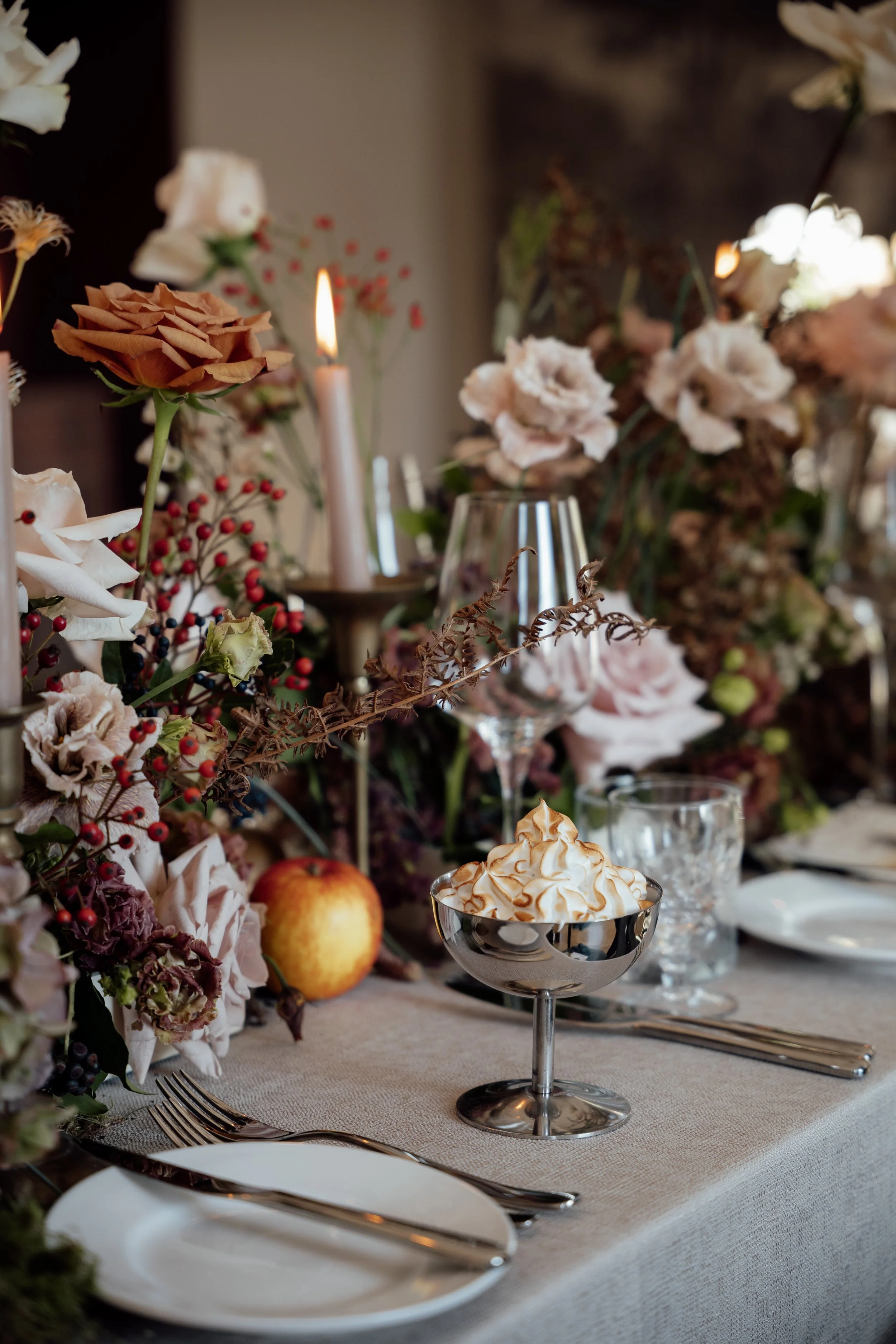 A beautifully styled wedding table at Cartmel, featuring soft florals, glowing candles and delicate place settings.