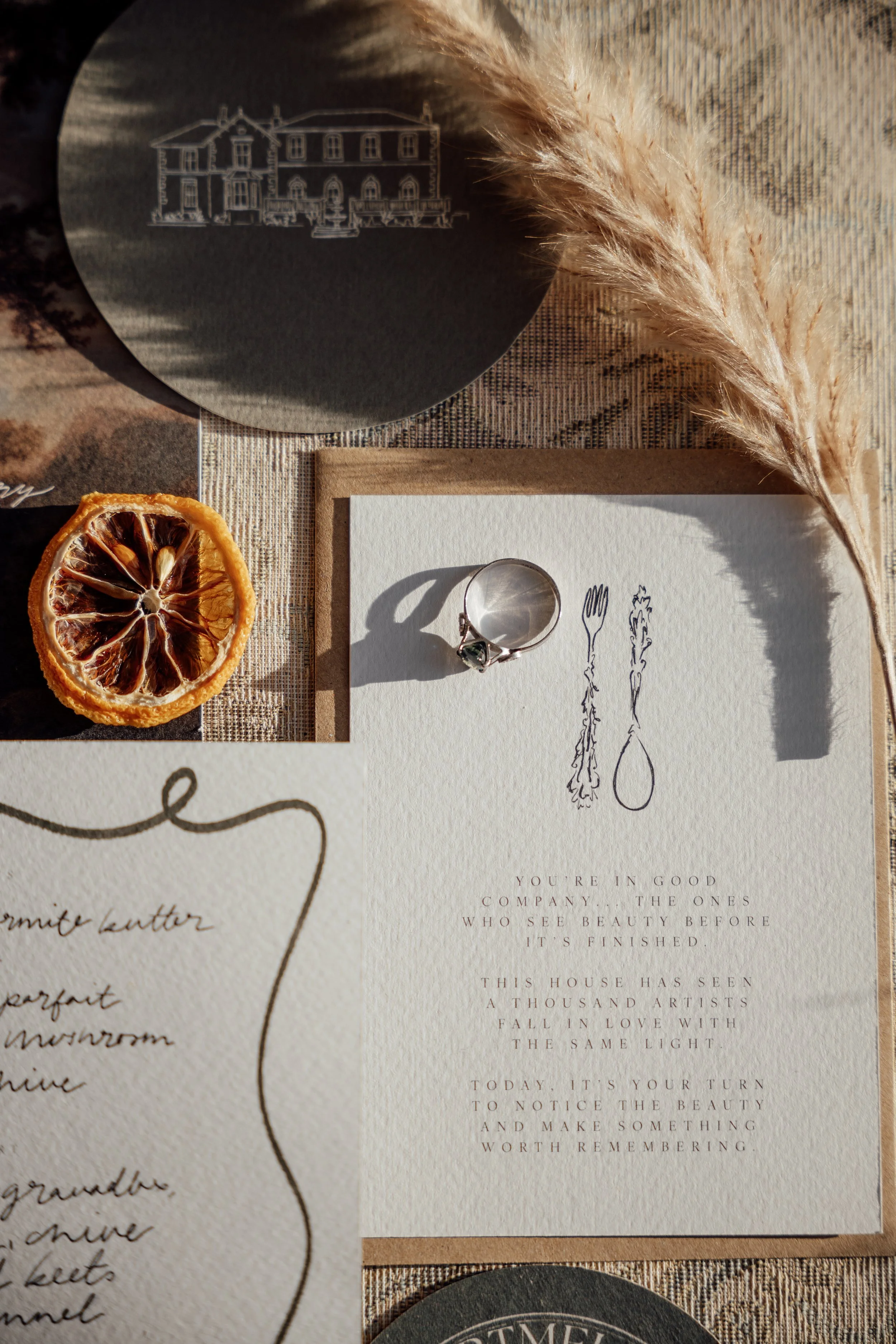 A flatlay of wedding menu cards and rustic table elements, styled with natural textures and warm tones.
