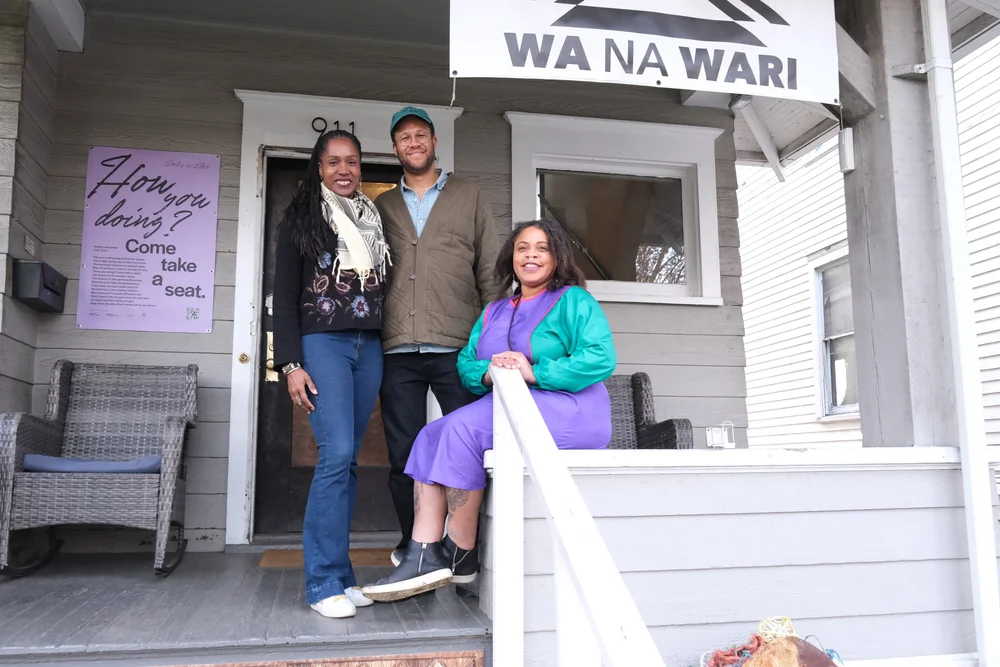  (Left to Right) Berette Macaulay, Simon Benjamin, and Elisheba Johnson on Wa Na Wari front porch 