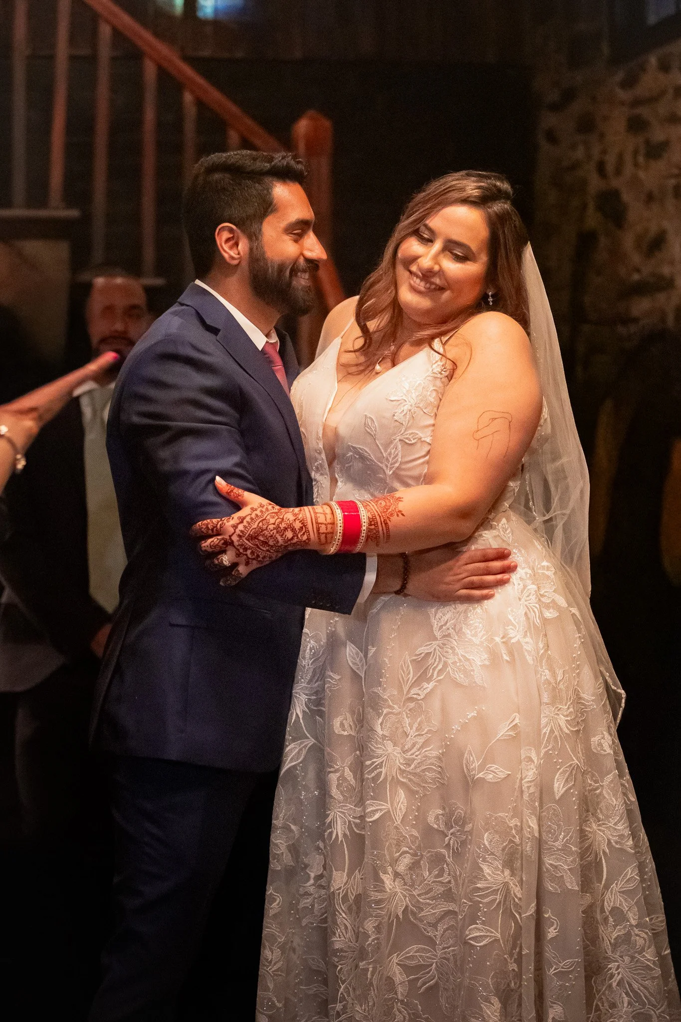 A wedding couple smiling at each other while dancing at their reception.