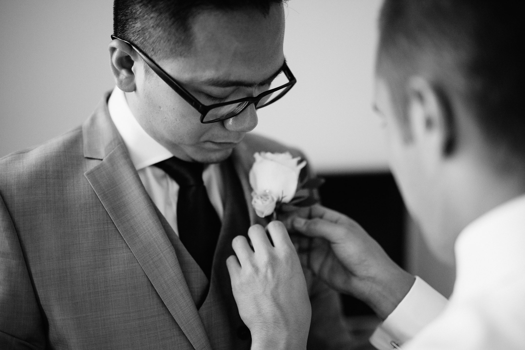  Groom has button hole pinned to his suit 