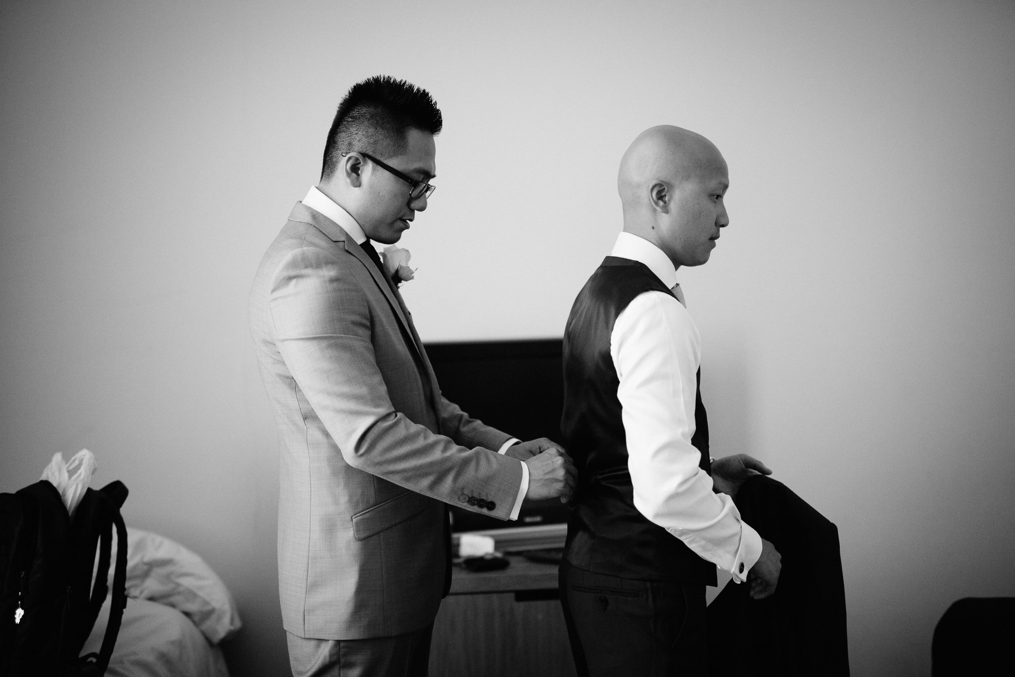  Groom helps usher with waistcoat 