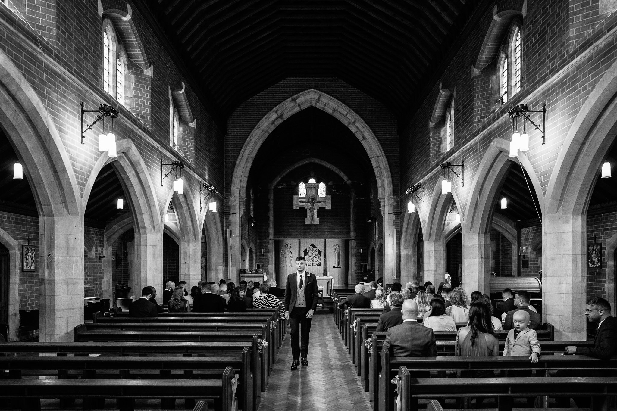  Groom walking down the aisle at The Holy Family Church in Reigate 