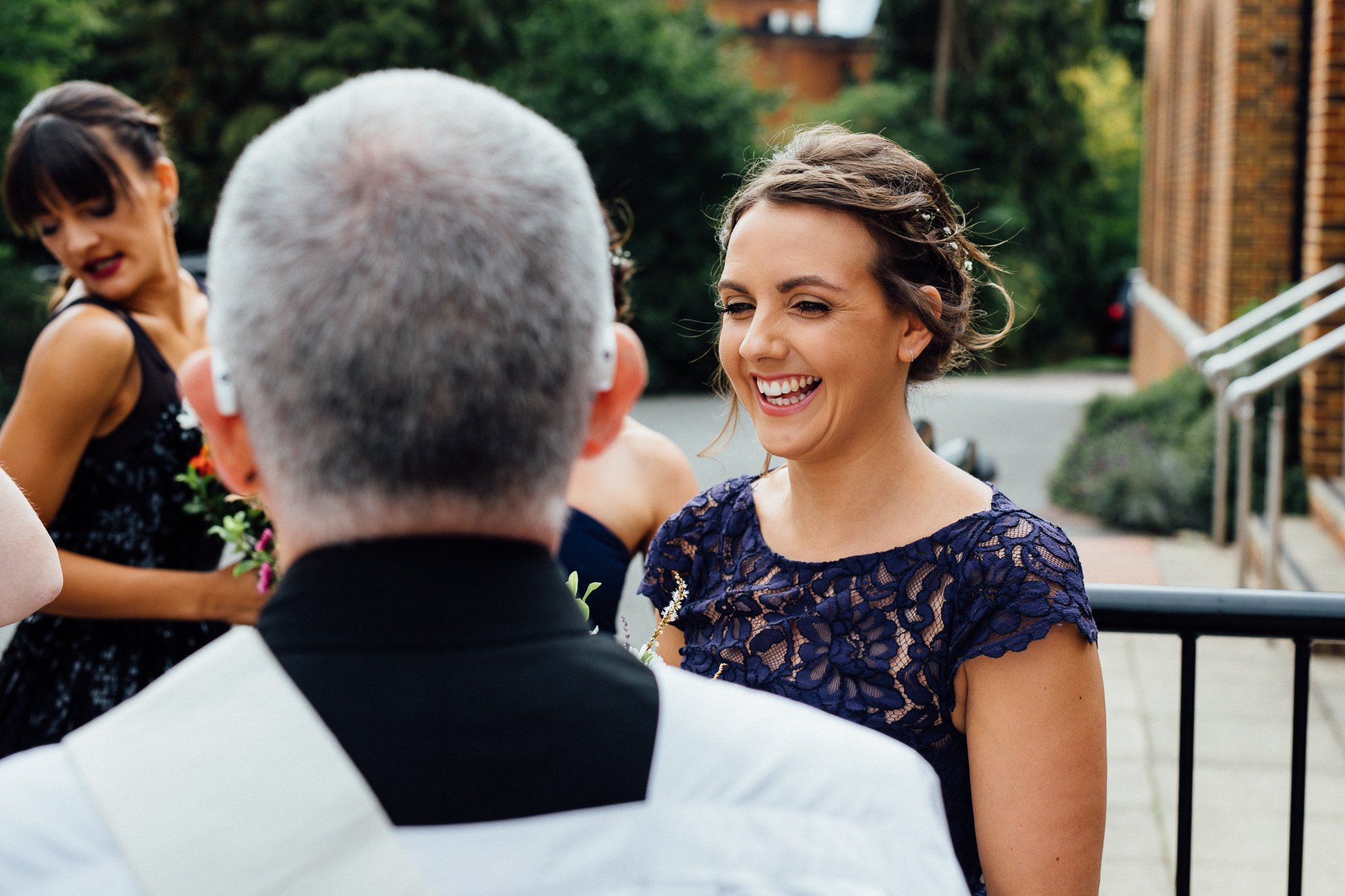  Bridesmaid talks to the vicar at The Holy Family Church in Reigate 