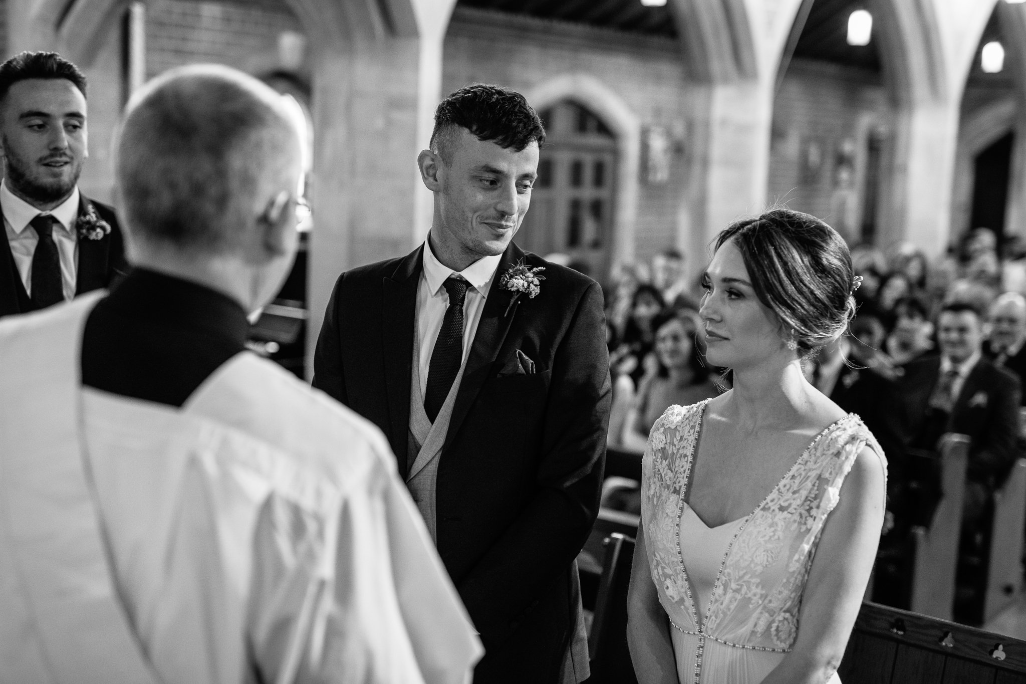  Groom looks adoringly at his bride at The Holy Family Church in Reigate 