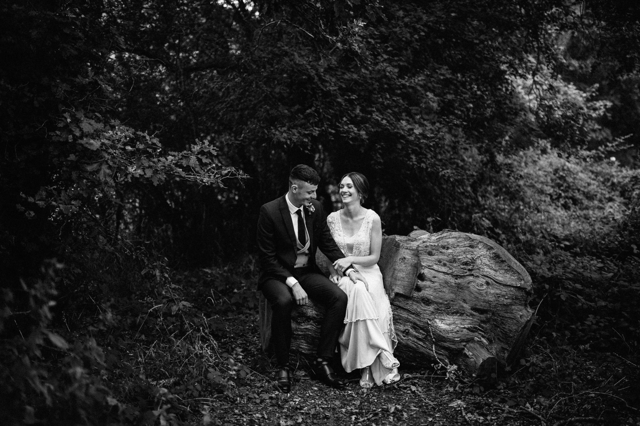  Bride and Groom sit in the grounds of Gildings Barns in Newdigate Surrey 