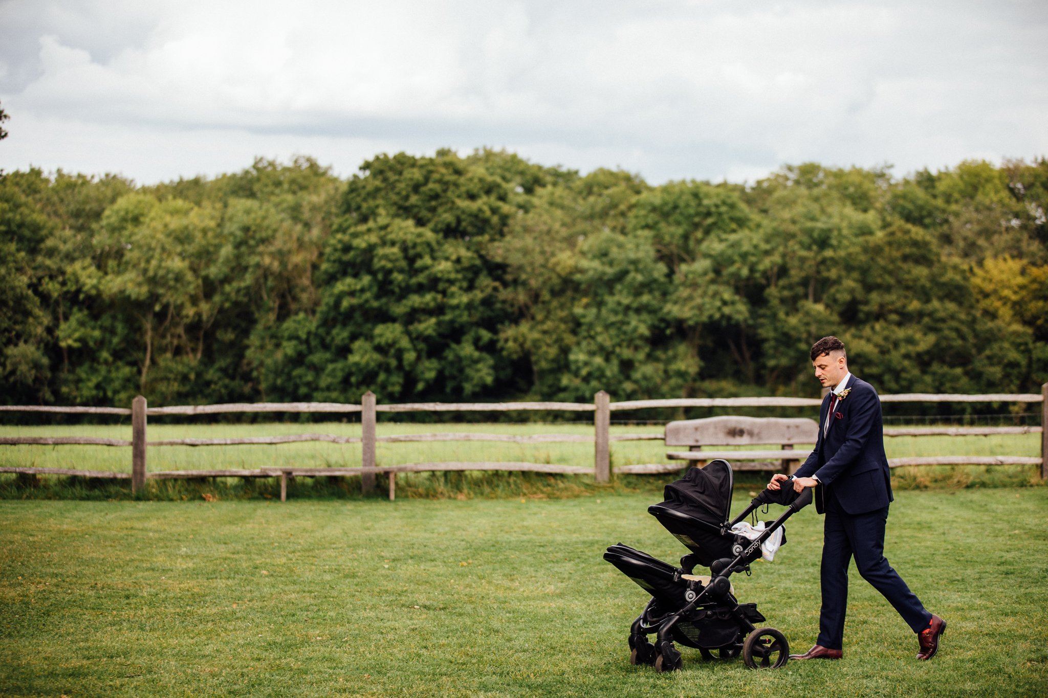  Groom pushing a buggy on a grass field 