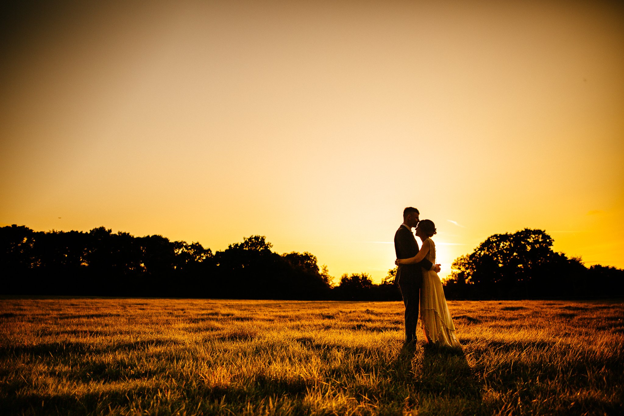  Sun sets behind Bride and Groom at Gildings Barns in Newdigate Surrey 