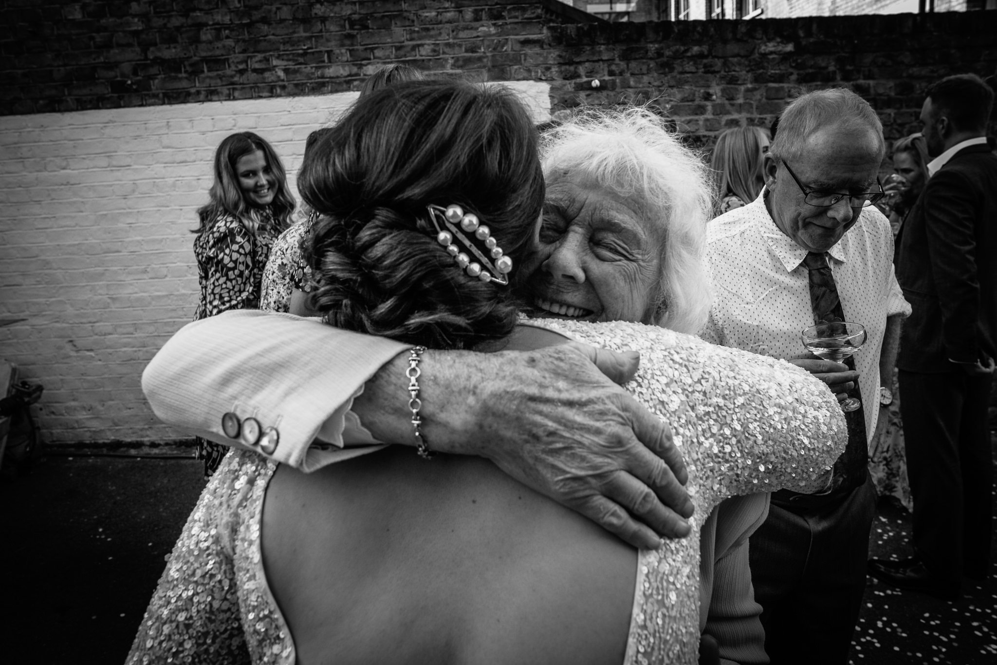  Bride hugs an elderly guest. 