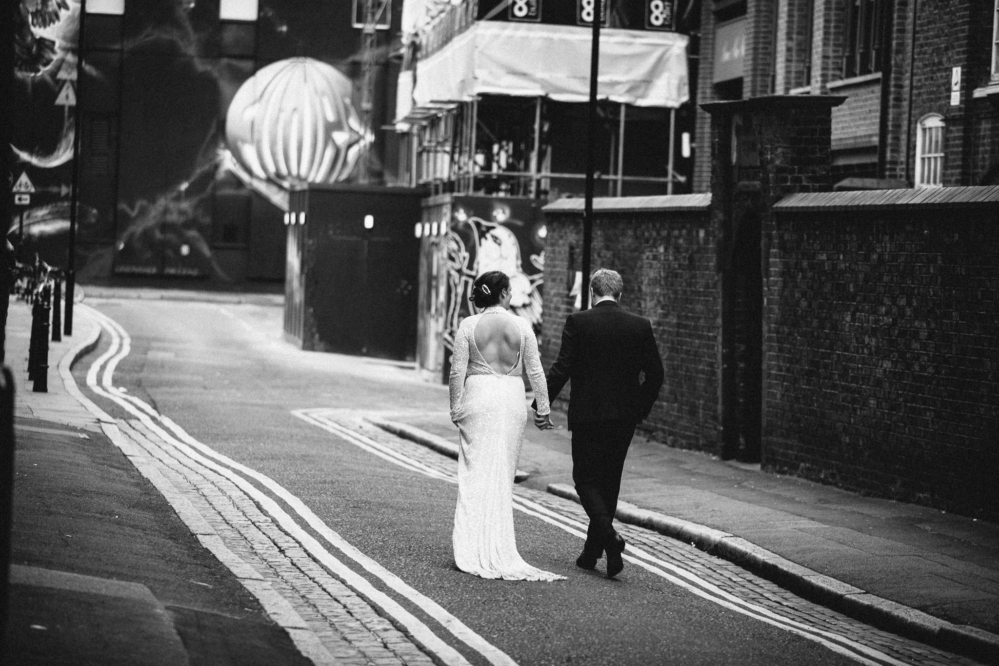  Bride and Groom walking together around the streets of Shoreditch. 