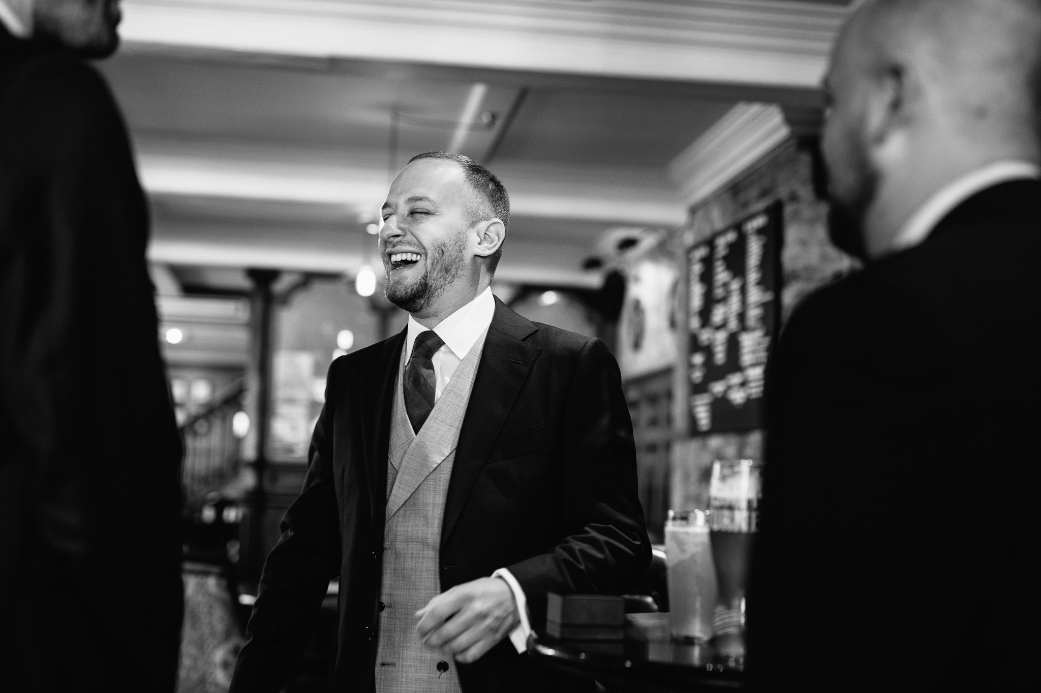  Groom laughs heartily as he talk to his friends 