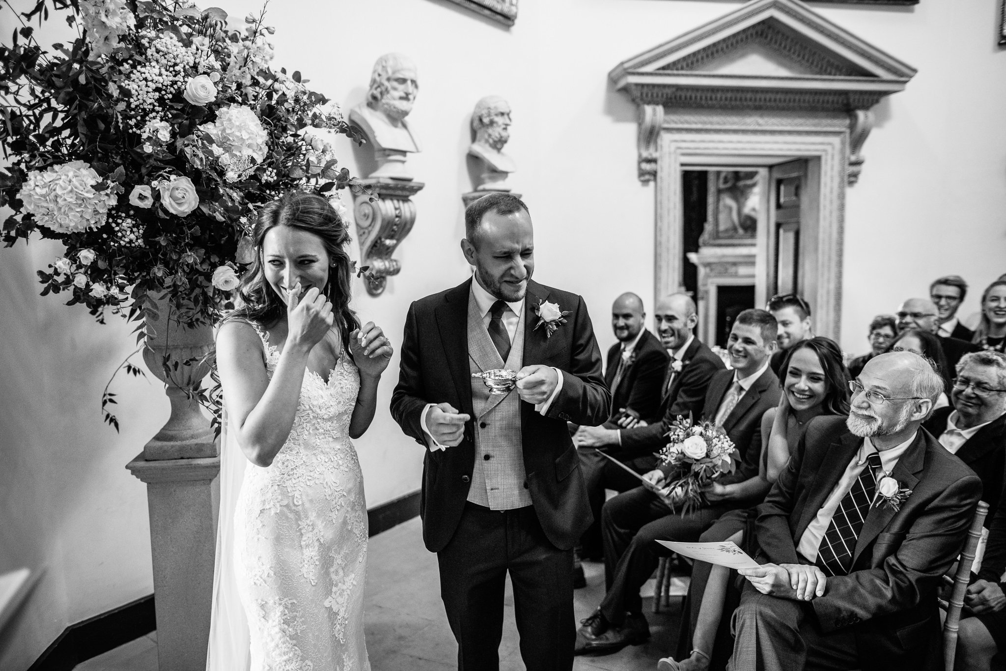  Grooms grimace from drinking the gin whilst the Bride laughs at his reaction 