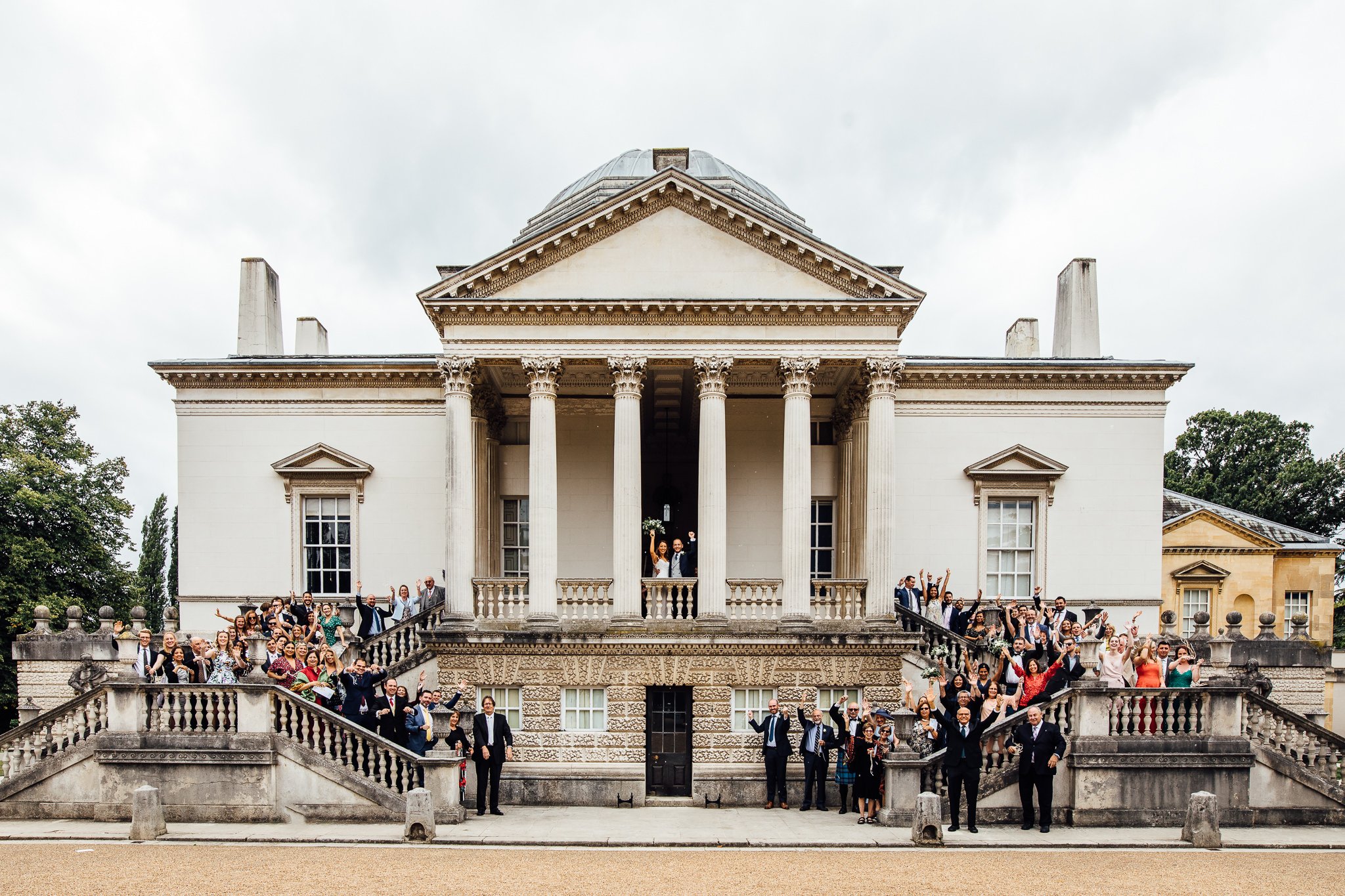  Group photo of all wedding guests at the front of Chiswick House 