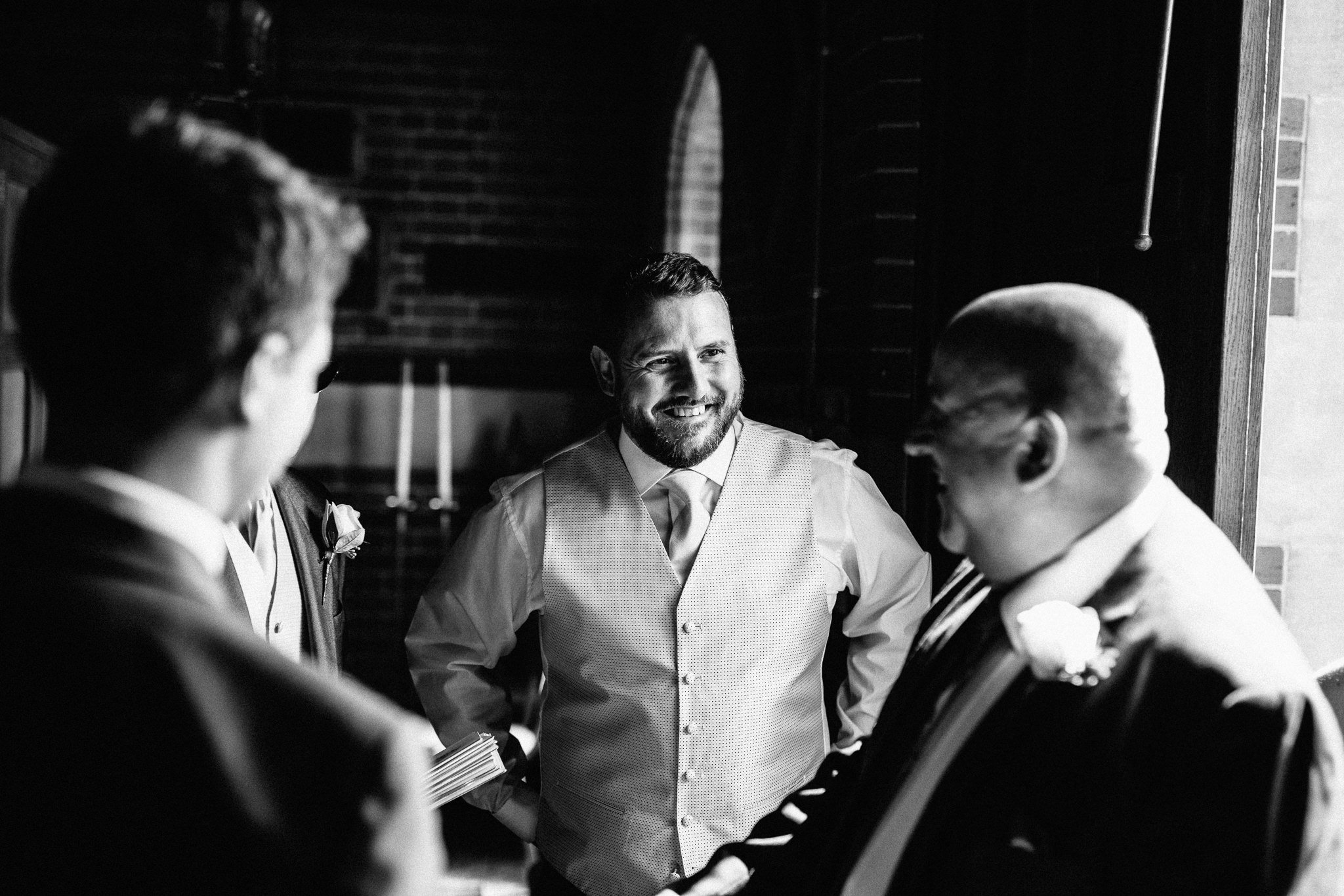  Groom smiling at the Chapel of St Luke at Epsom College 