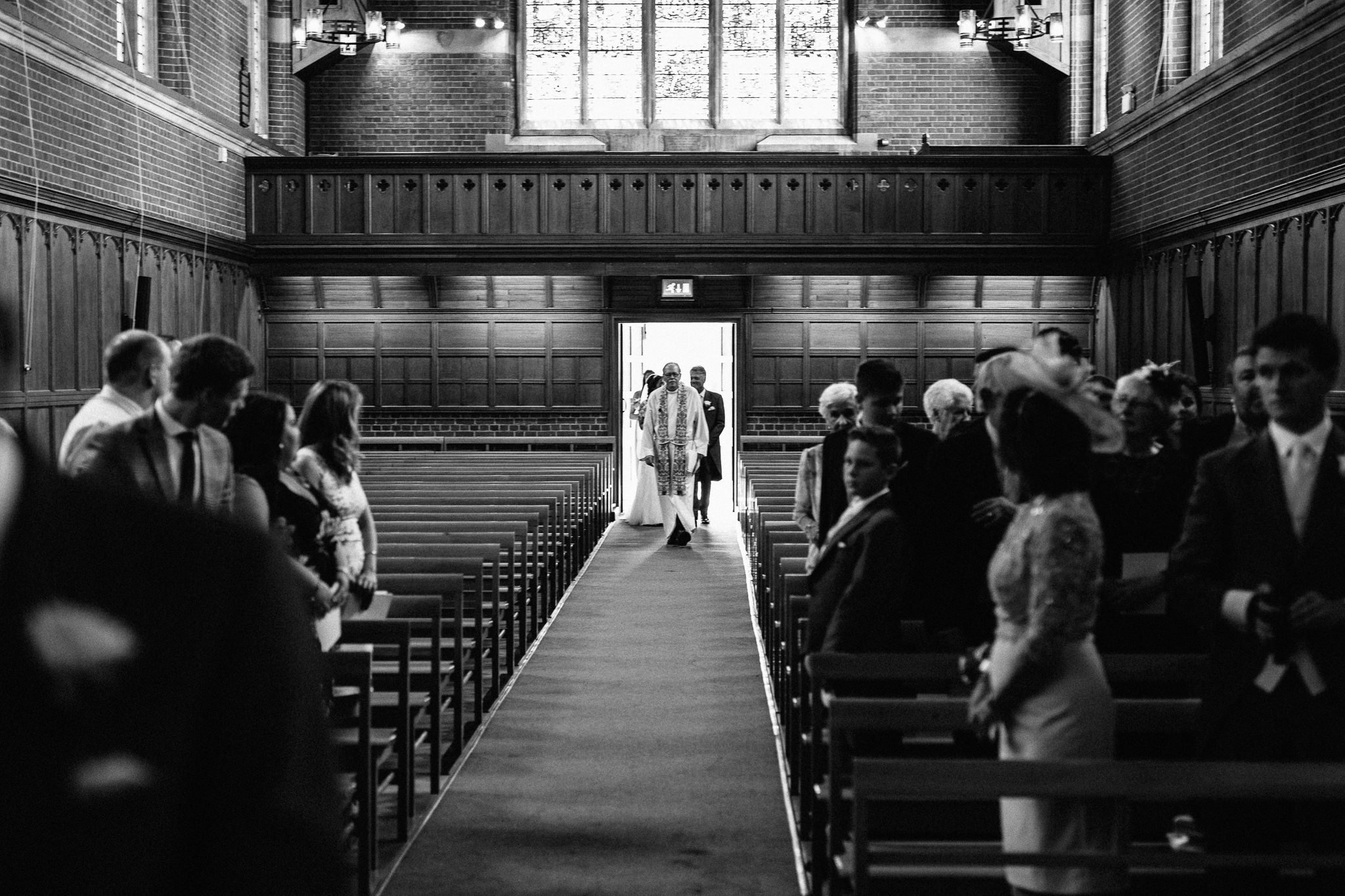  Vicar walks down the aisle  at the Chapel of St Luke at Epsom College 