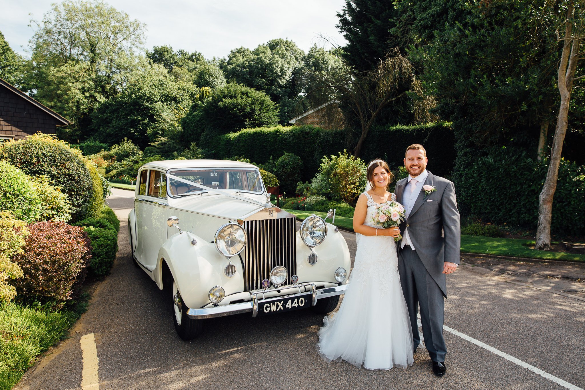  Bride and Groom stand next to their wedding car at walton heath golf club surrey 