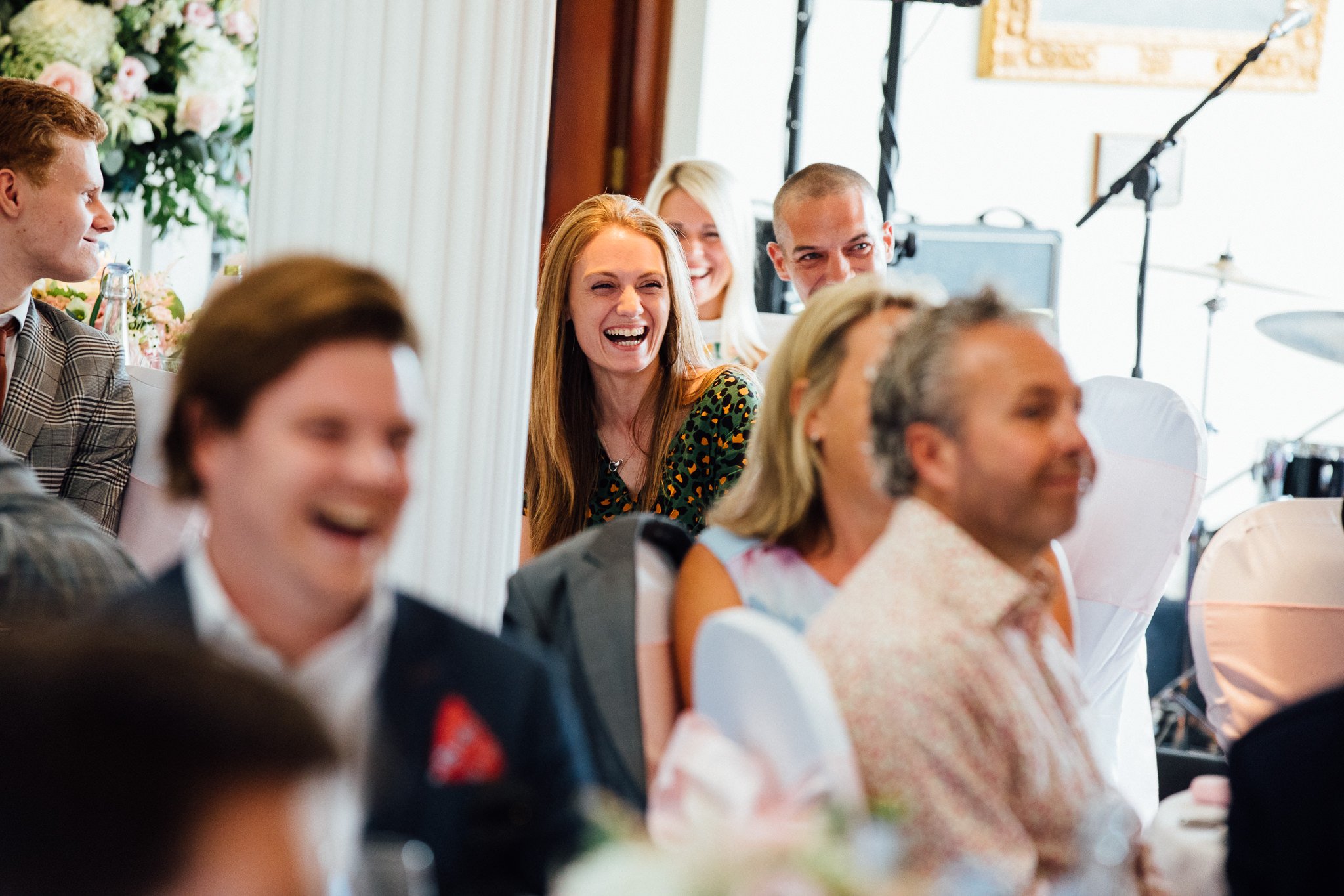  Female wedding guest laughing  at Walton Heath Golf Club Surrey 