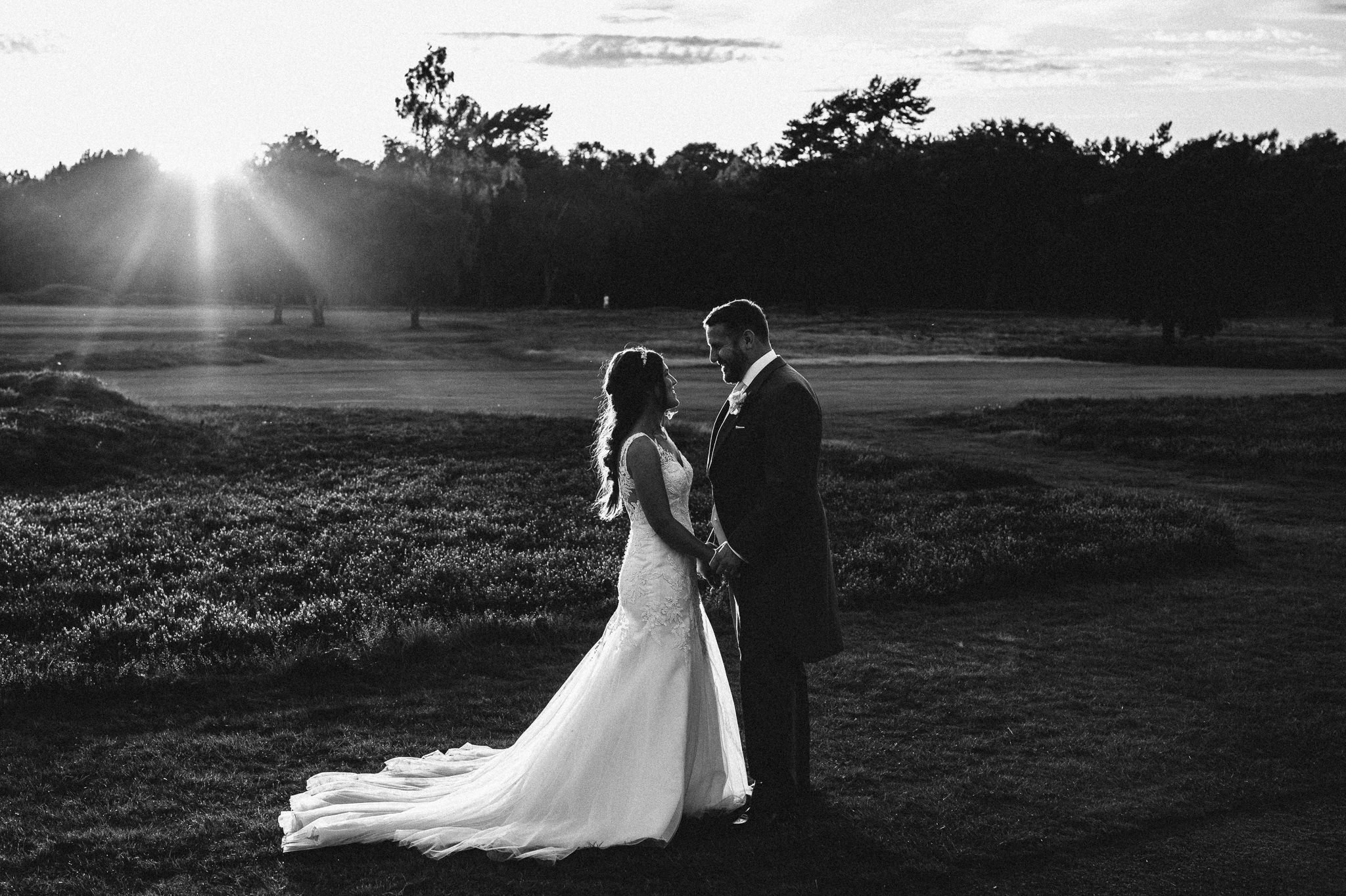  Bride and Groom looking at each other as the sun sets in the background on the golf course  at Walton Heath Golf Club Surrey 