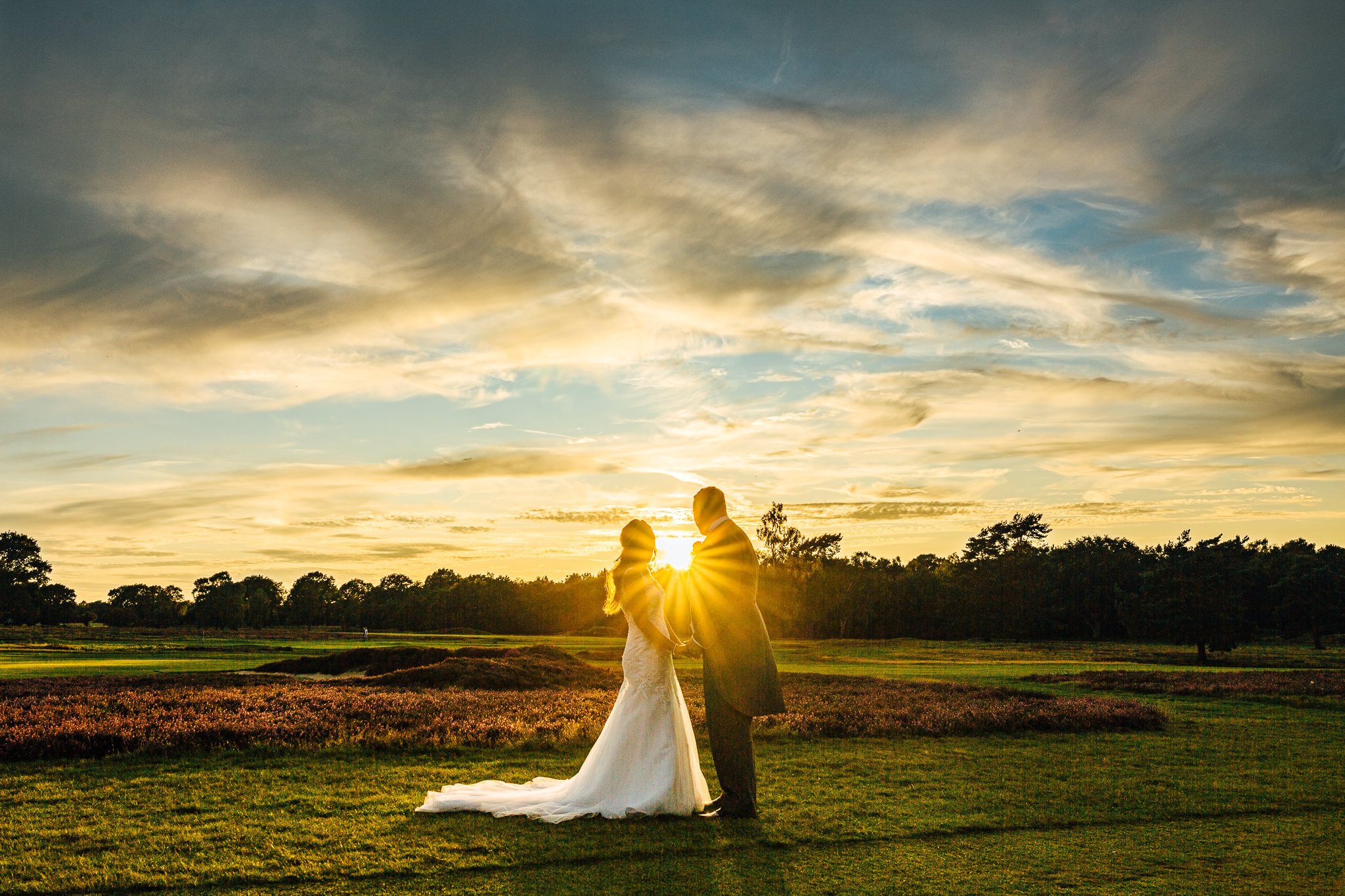  Bride and Groom look into the setting sun  at Walton Heath Golf Club Surrey 