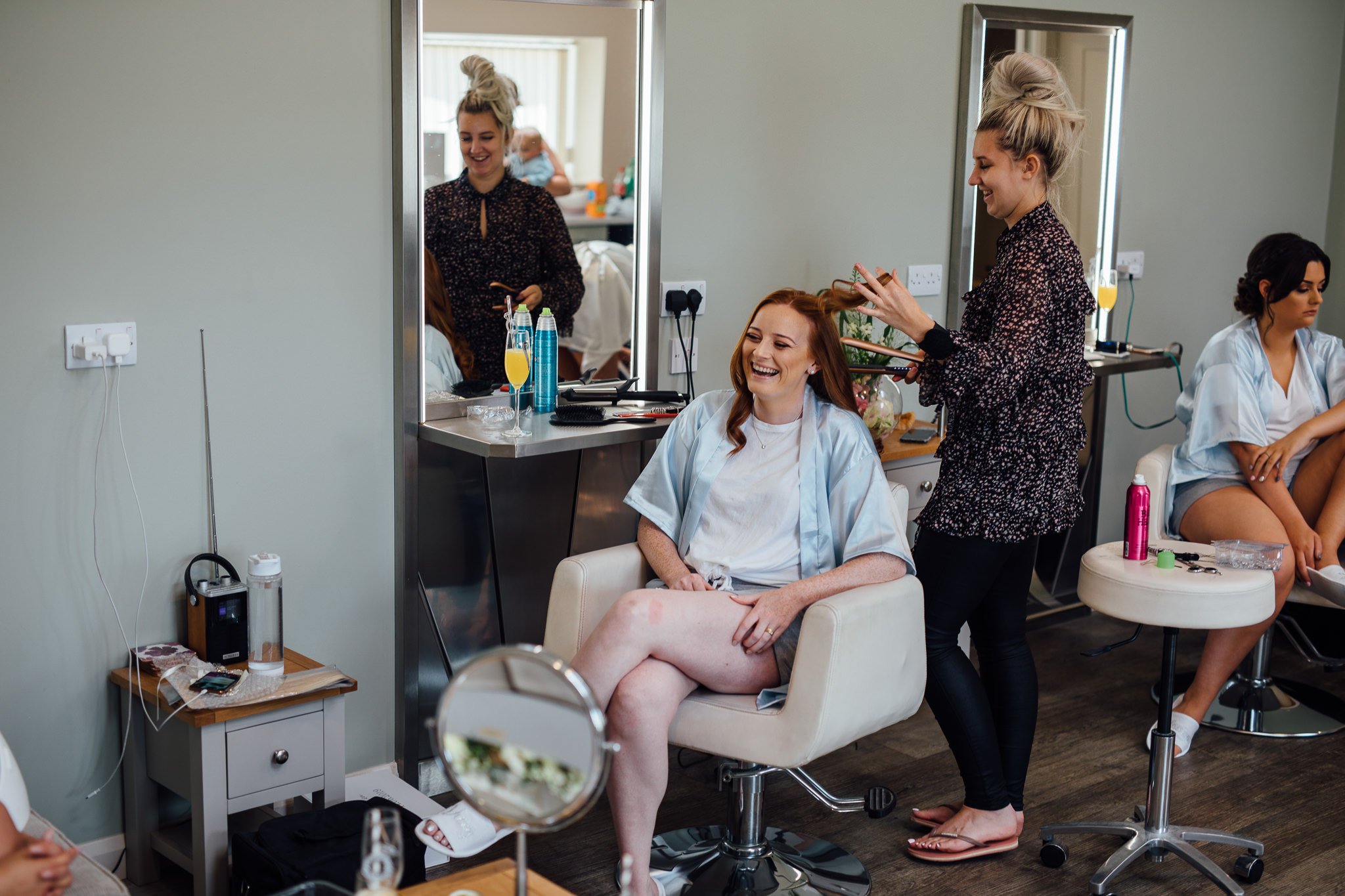  Bridal party member laughing whilst having her hair done. 