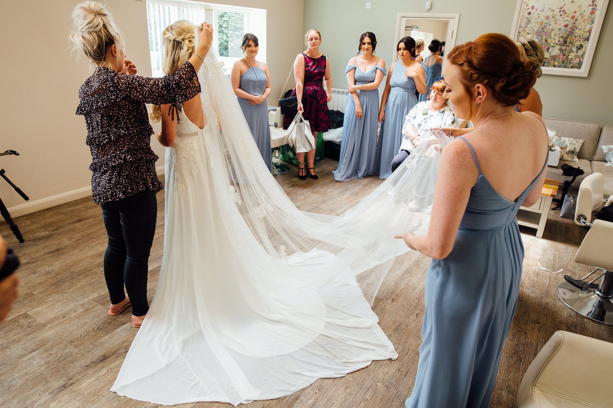  The bridal party gather around to see the Bride in her dress 