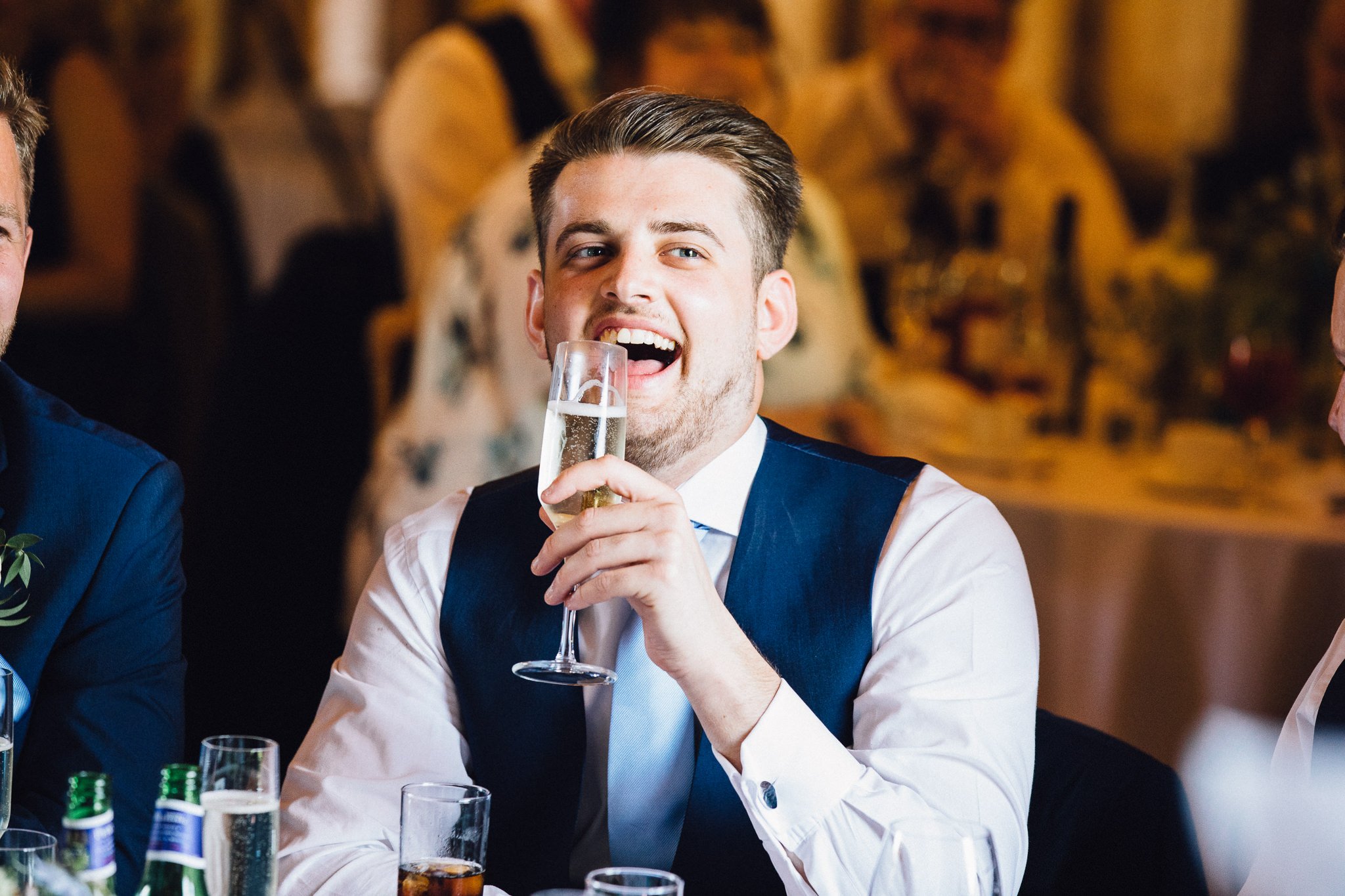  Groomsman laughs during the speeches  