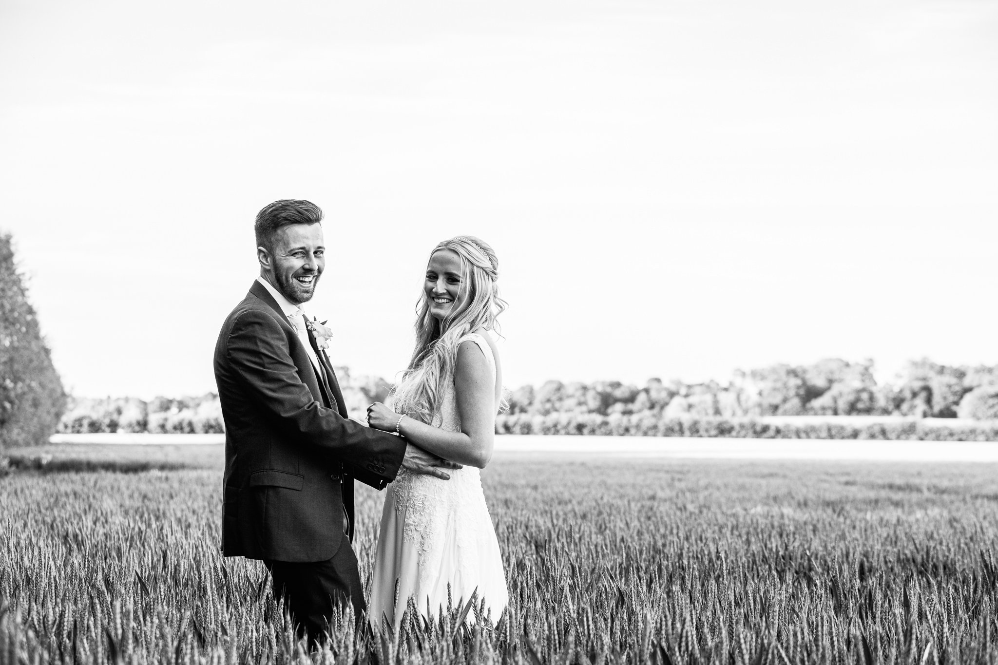  Bride and Groom smiling in a field at Winters Barns Wedding Venue Kent 