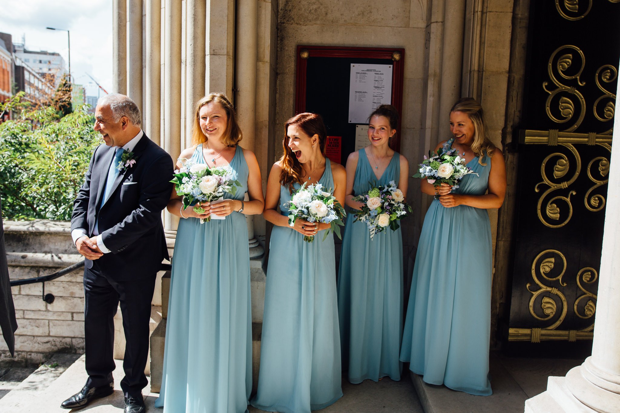  Bridemaids react to seeing the bride outside St James Church, Spanish Place Marlyborne 