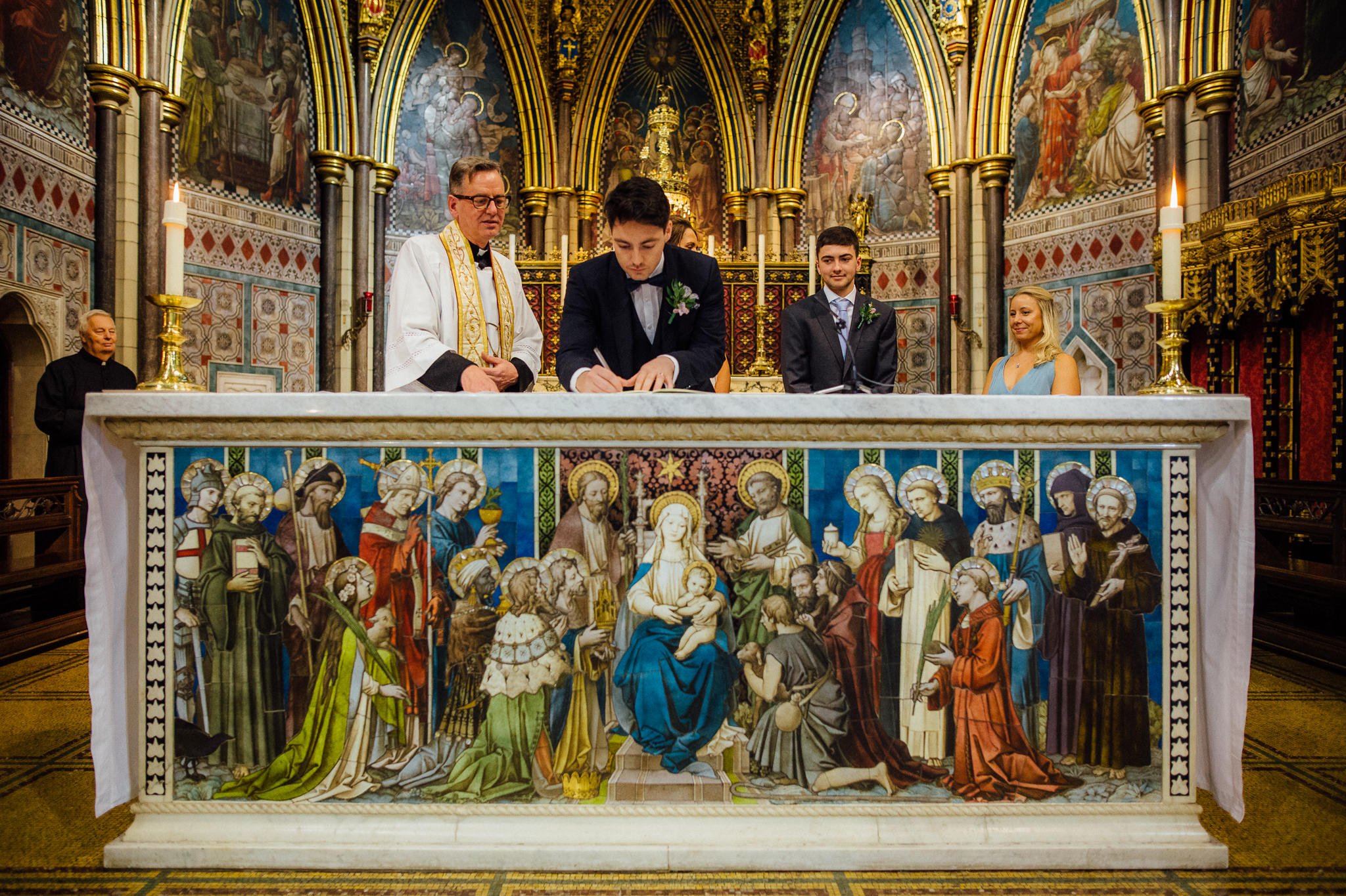  Groom signs marriage certificate atop an ornate plinth at St James Church, Spanish Place Marlyborne 
