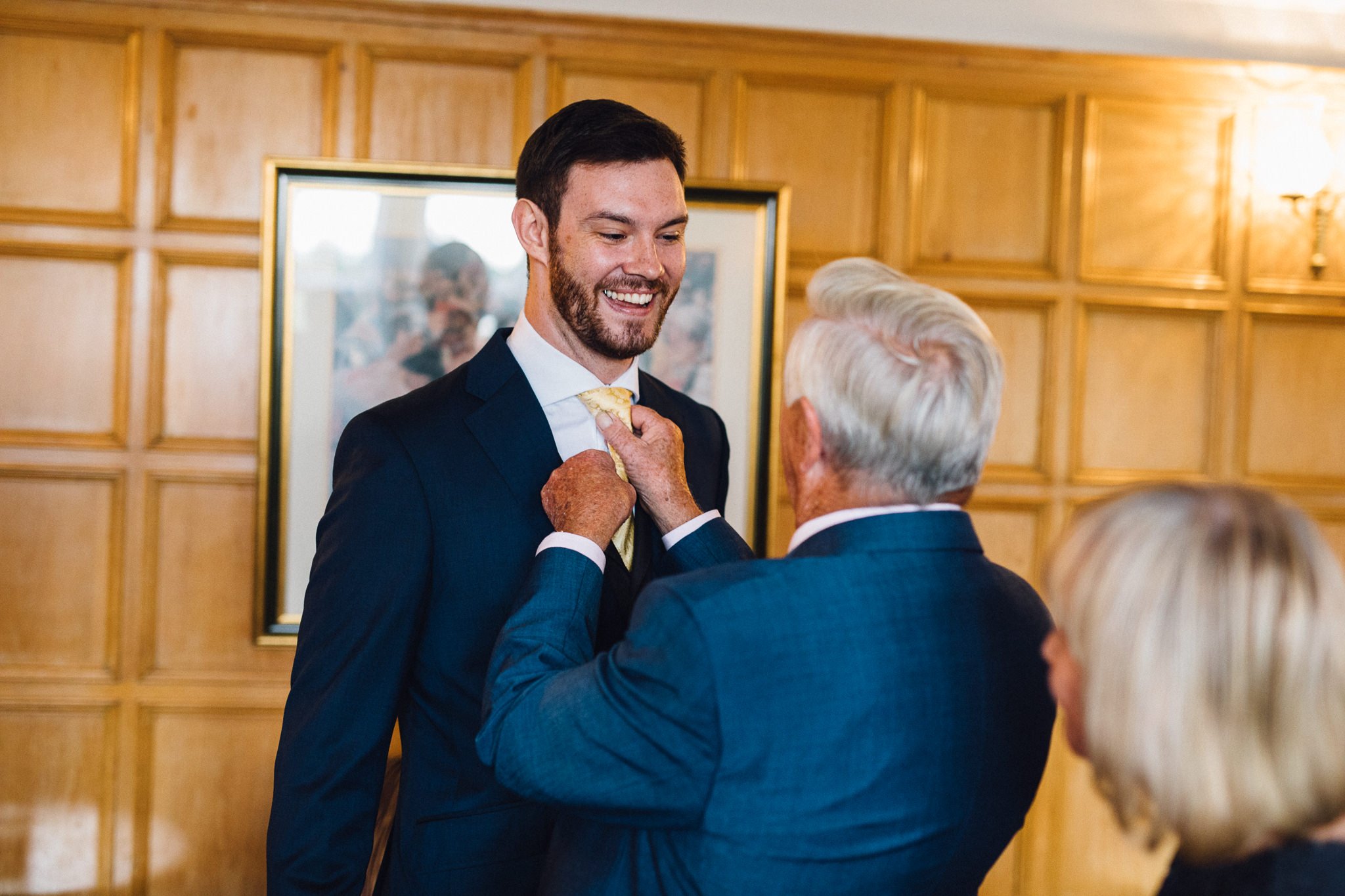  Groom having his tie adjusted on his wedding day at Warren House Hotel Kingston upon Thames 