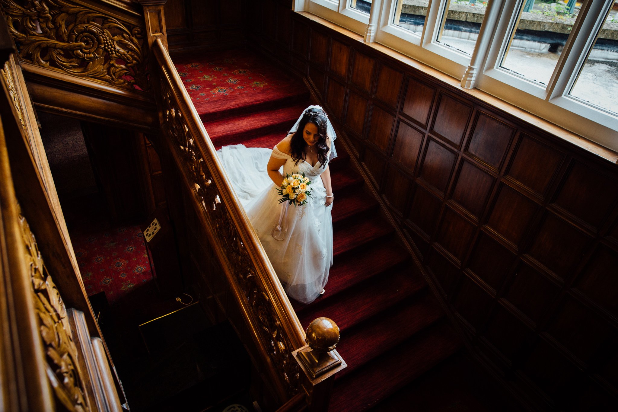  Bride descends the stairs at Warren House Hotel Kingston upon Thames 
