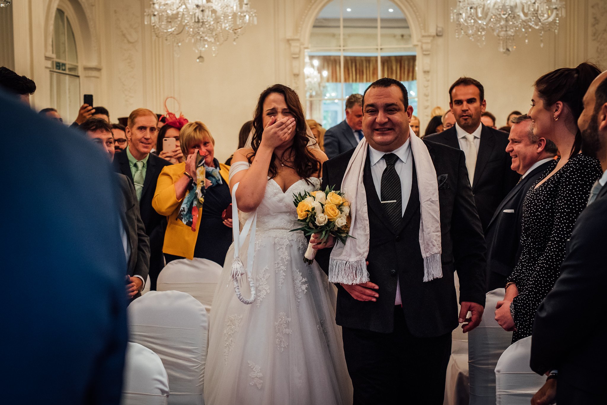  Bride is overcome with emotion as she walks down the aisle at Warren House Hotel Kingston upon Thames 